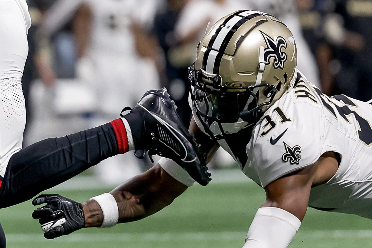 El defensor de New Orleans Saints de Atlanta Jordan Howden (derecha) es superado por el corredor Atlanta Falcons Bijan Robinson durante el juego de este domingo en Atlanta.EFE/EPA/ERIK S. LESSER