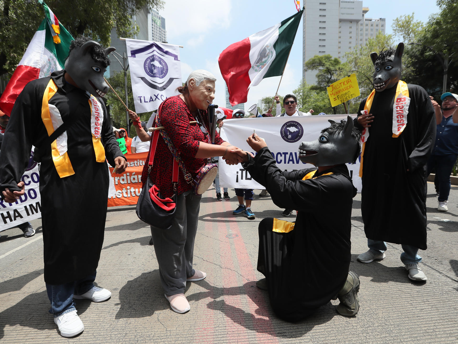 Un trabajador del poder judicial caracterizado como el presidente de México, Andrés Manuel López Obrador (c), participa en una protesta este jueves, al exterior de la Cámara de Senadores en la Ciudad de México (México). EFE/ Mario Guzmán
