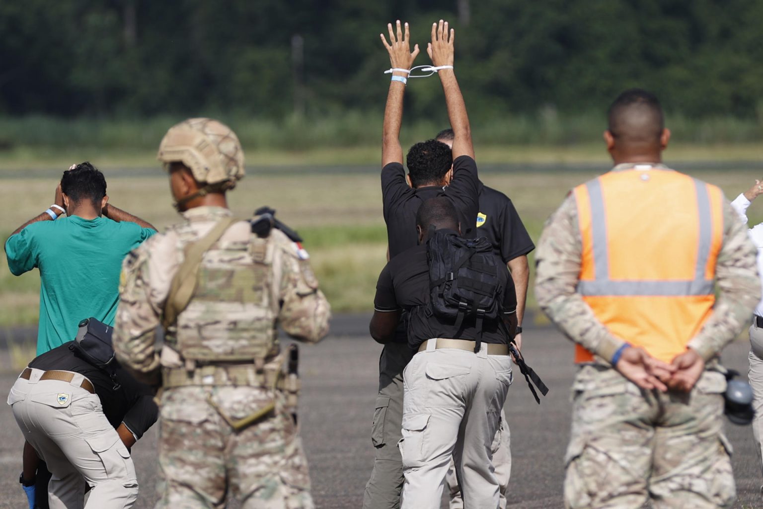 Integrantes del Servicio Nacional Aeronaval de Panamá (Senan) requisan a migrantes antes de subir a un avión parte de un plan de deportación de extranjeros ilegales. EFE/ Bienvenido Velasco