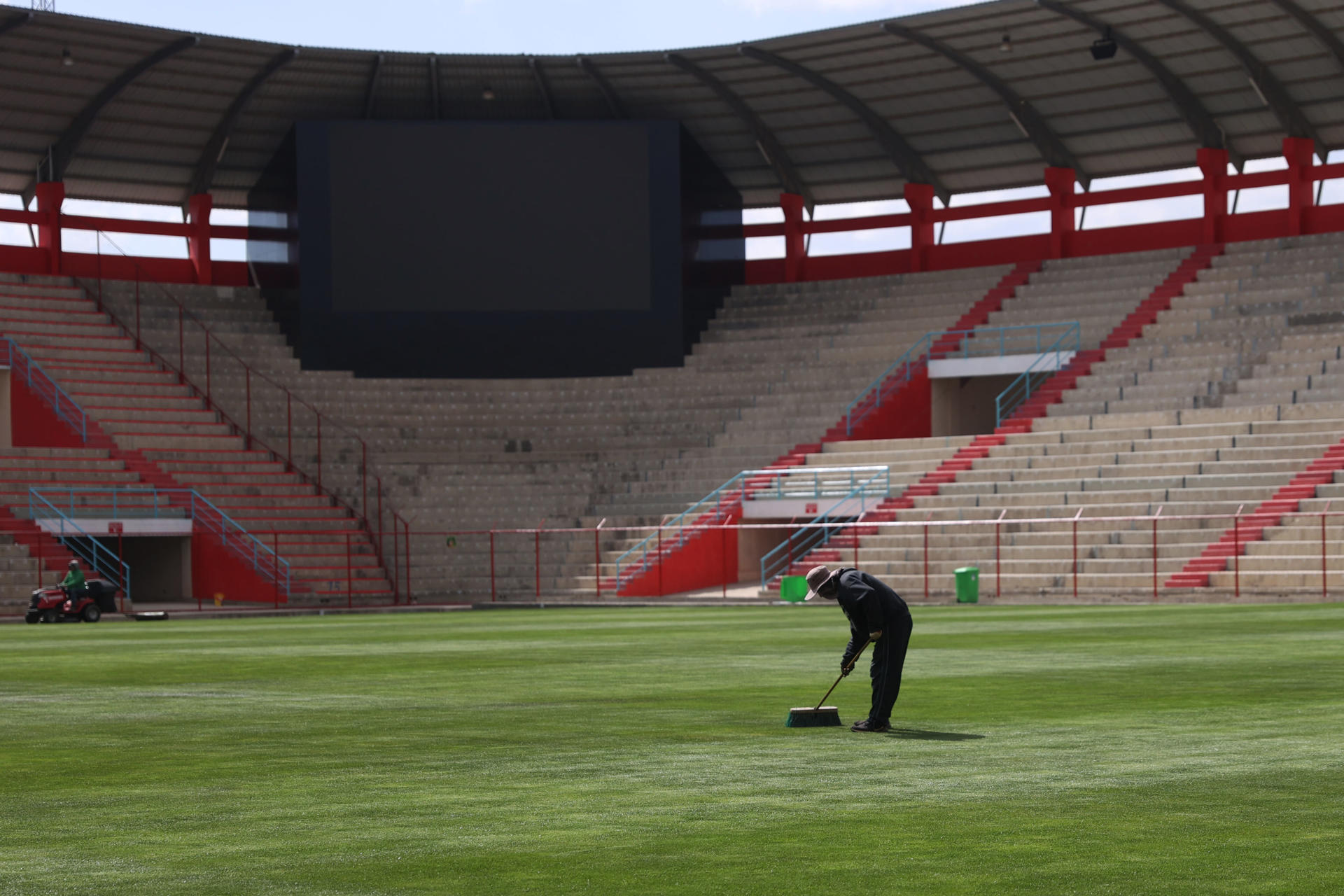 Fotografía del 29 de agosto de 2024 de un trabajador dando mantenimiento al césped del estadio Municipal de El Alto, nueva sede de la selección de fútbol de Bolivia. EFE/ Luis Gandarillas
