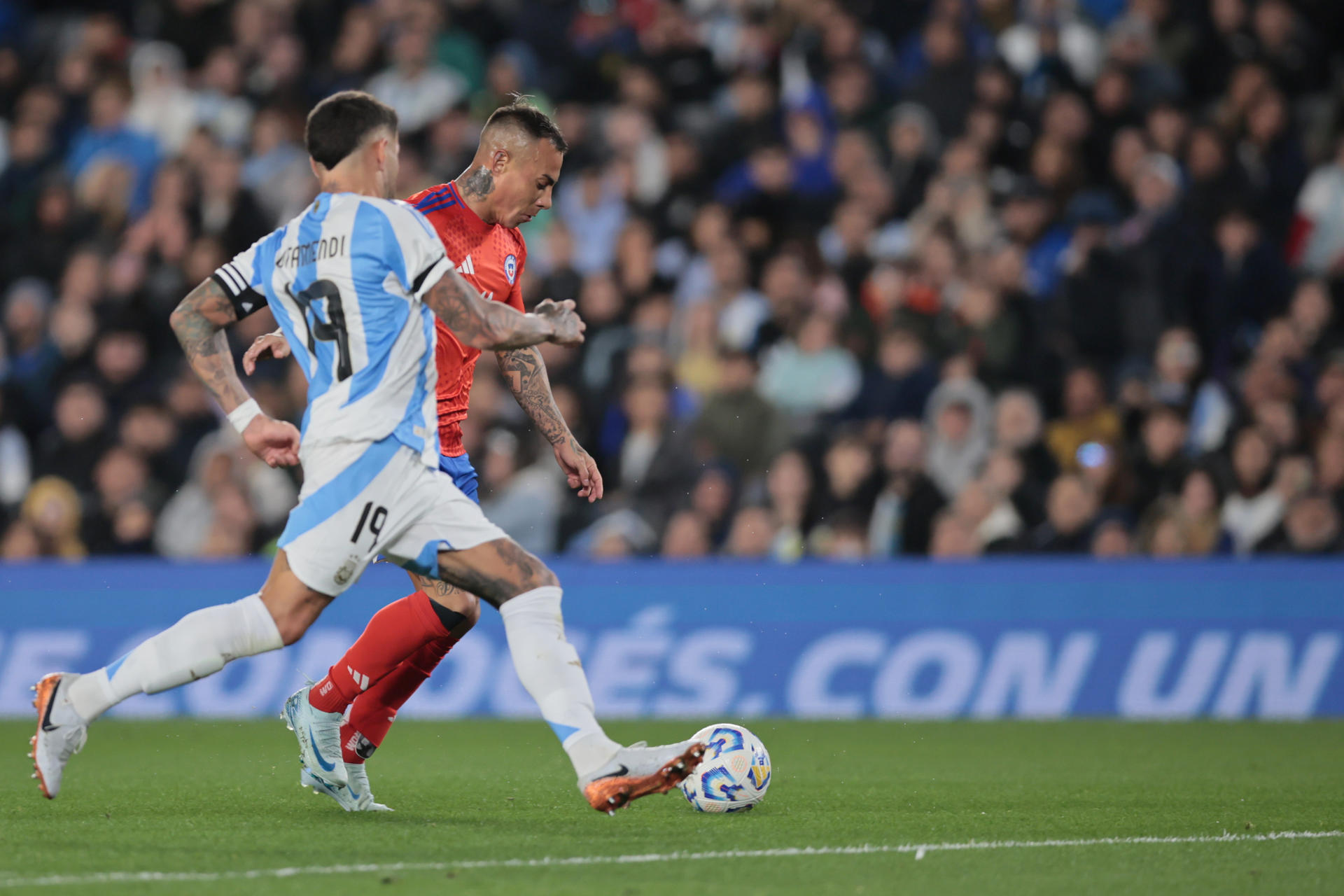 Nicolás Otamendi (i) de Argentina disputa un balón con Eduardo Vargas de Chile en un partido de las eliminatorias sudamericana para el Mundial 2026. EFE/ STR
