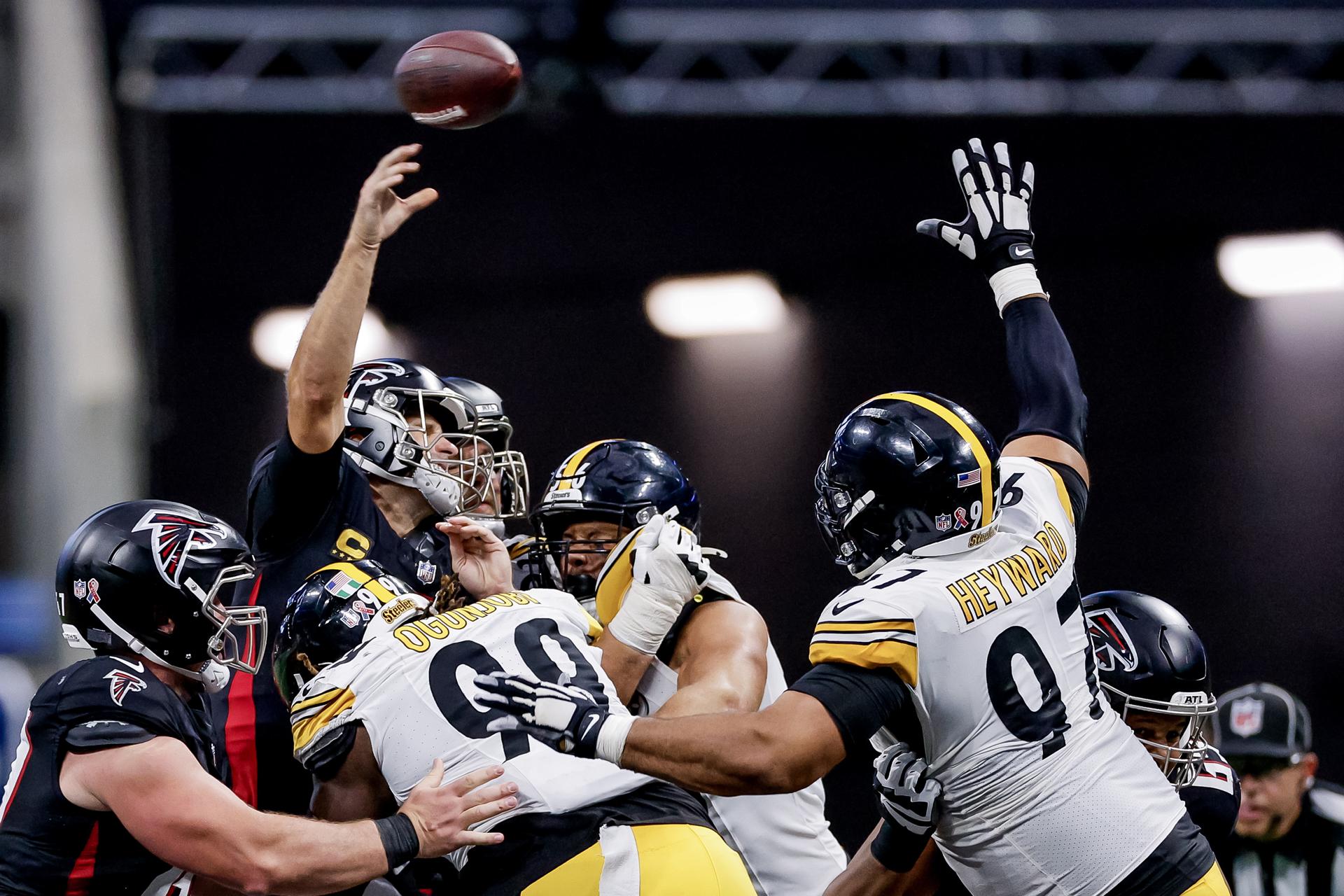 El mariscal de campo de los Falcons, Kirk Cousins, (i) intenta pasar el balón con la marca de los jugadores de los Steelers Larry Ogunjobi (c) y Cameron Heyward (d). EFE/EPA/ERIK S. LESSER
