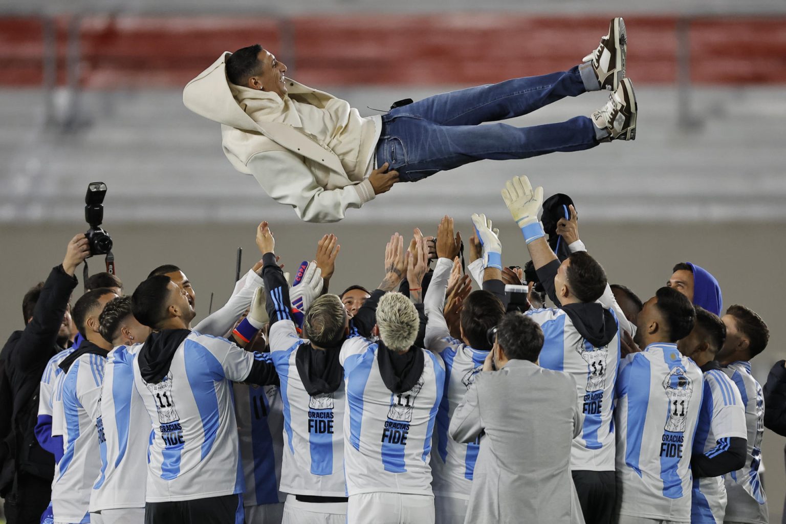 Jugadores de Argentina lanzan a Ángel di María (arriba) previo a un partido de las eliminatorias sudamericana para el Mundial 2026. EFE/ Juan Ignacio Roncoroni