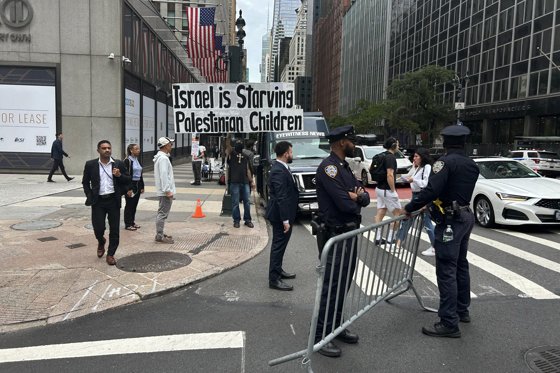 Personas pasan junto a una pancarta que dice 'Israel está matando de hambre a los niños palestinos' este lunes, frente de la sede de las Naciones Unidas en Nueva York (EE.UU.). EFE/ Javier Otazu
