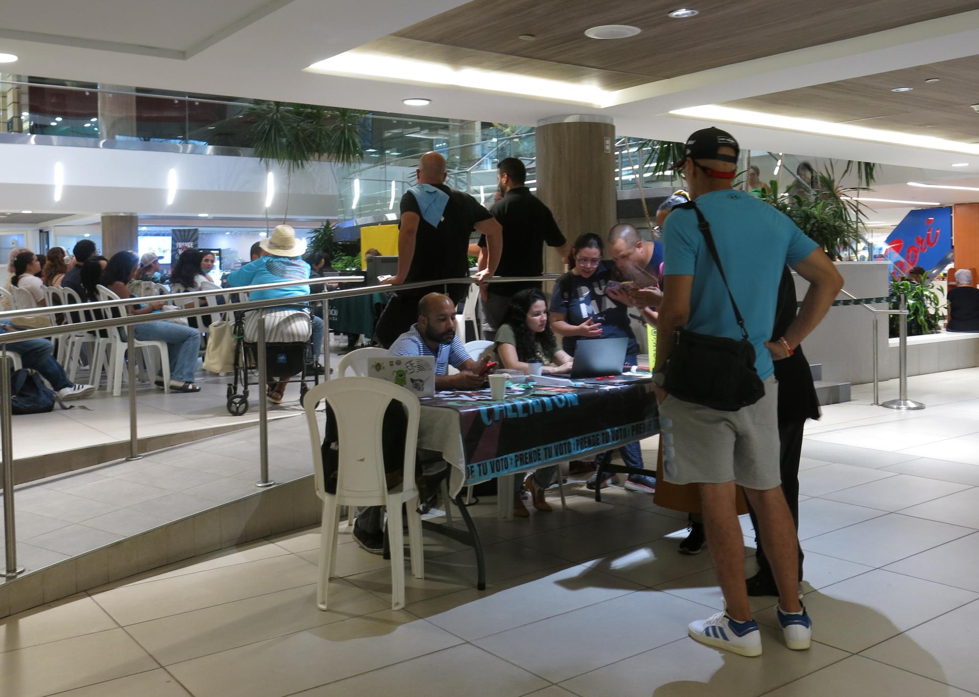 Unas personas se inscriben en el registro de votantes, en el centro de inscripción habilitado en por un día en el Centro Comercial de San Patricio en San Juan, Puerto Rico. EFE/Esther Alaejos
