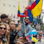 Una mujer ondea una bandera colombiana mientras observa el desfile del Día de la Hispanidad en la Quinta Avenida de Nueva York (EE.UU.). Archivo. EFE/ Ángel Colmenares