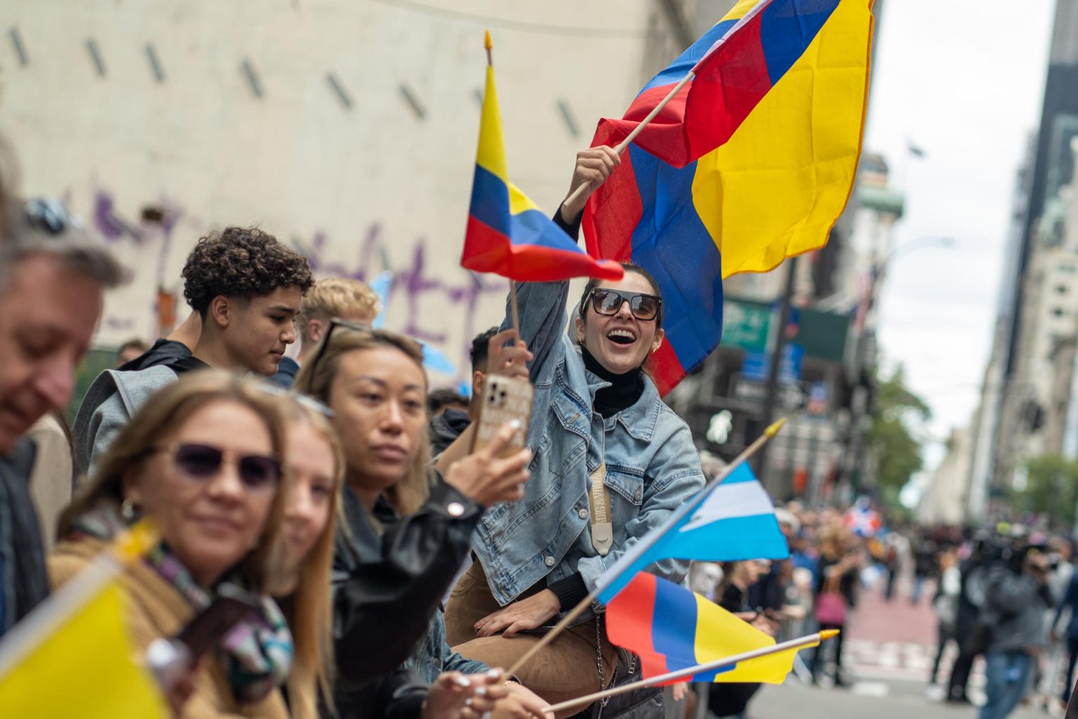 Una mujer ondea una bandera colombiana mientras observa el desfile del Día de la Hispanidad en la Quinta Avenida de Nueva York (EE.UU.). Archivo. EFE/ Ángel Colmenares