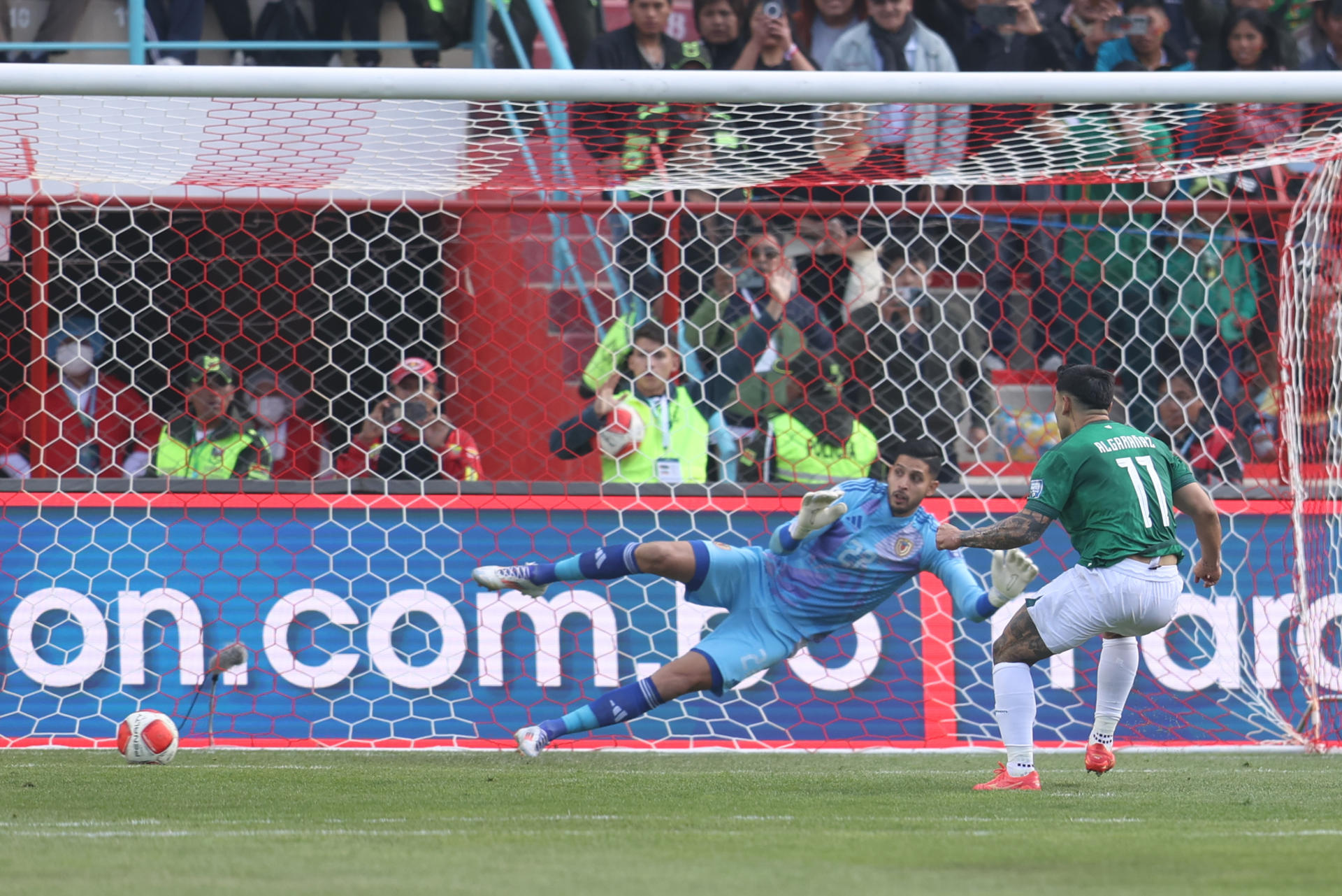 Carmelo Algarañaz (d), delantero de Bolivia, fue registrado este jueves, 5 de septiembre, al anotarle de penal un gol al guardameta venezolano Rafael Romo (c), durante un partido de la fecha 7 de las Eliminatorias Suramericanas al Mundial FIFA de 2026, en el estadio Municipal de El Alto (Bolivia). EFE/Luis Gandarillas
