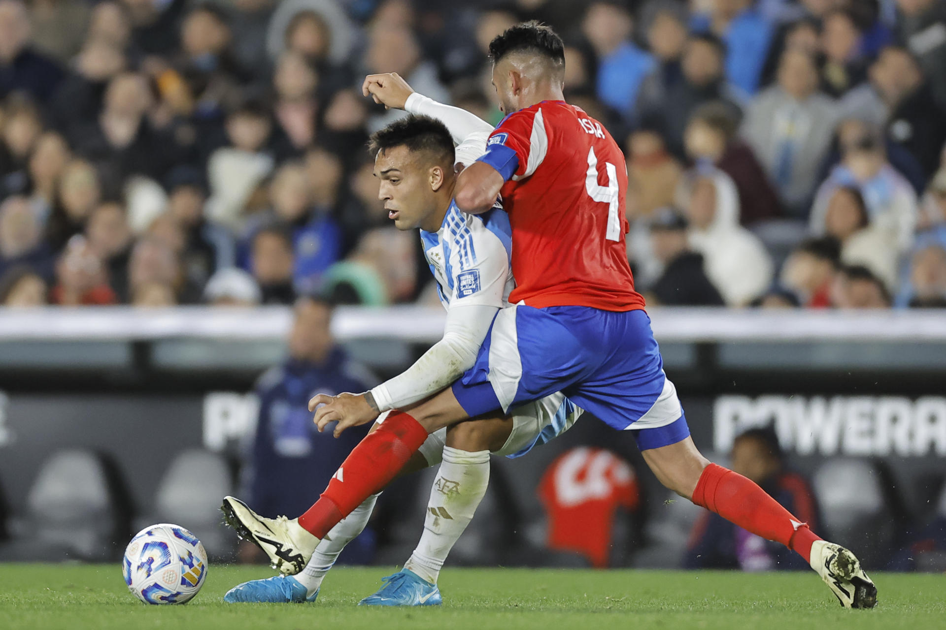 Lautaro Martínez (i) de Argentina disputa un balón con Mauricio Isla de Chile en un partido de las eliminatorias sudamericana para el Mundial 2026. EFE/ Juan Ignacio Roncoroni
