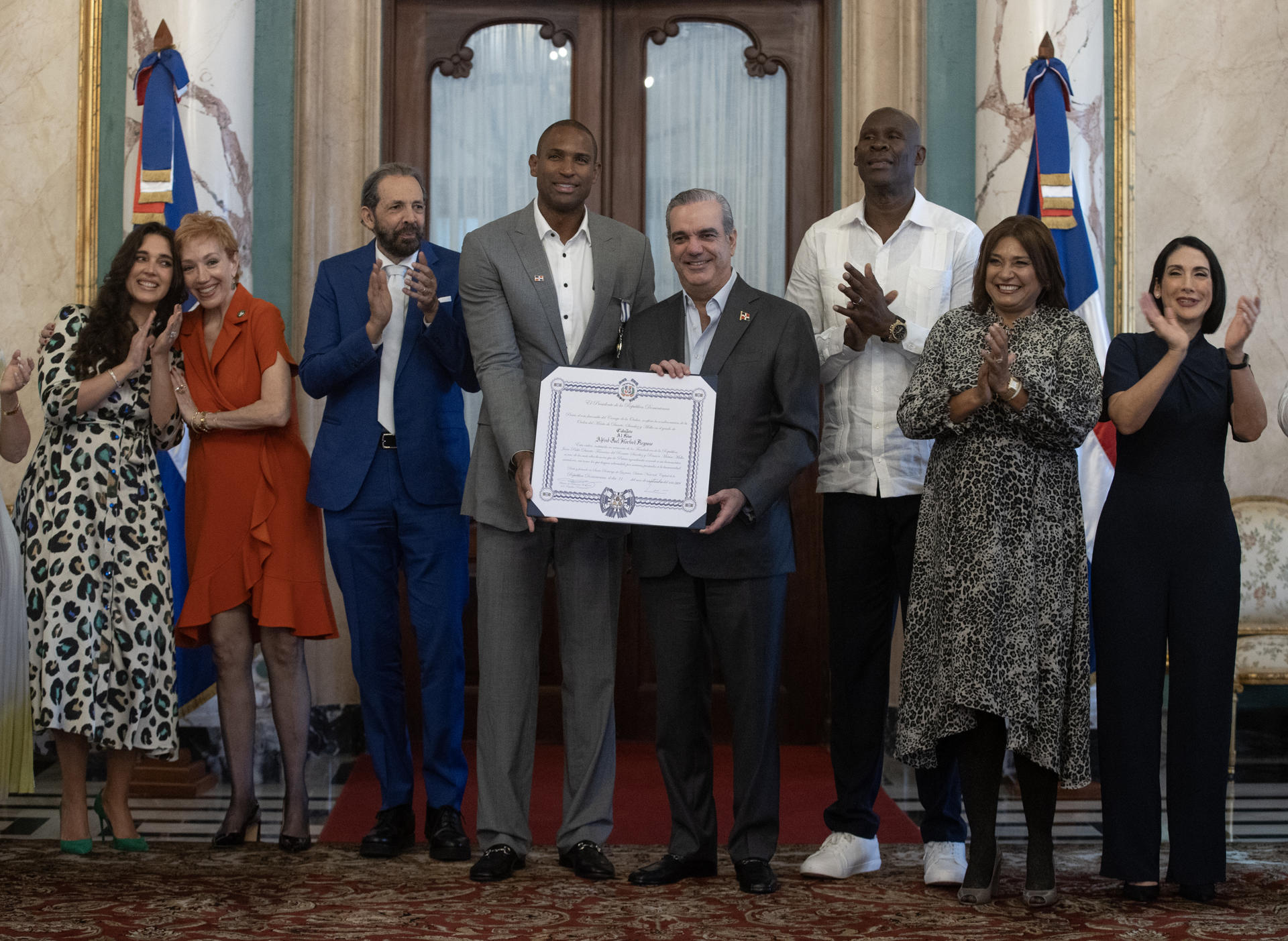 Al Horford (4i) posa con el presidente de República Dominicana, Luis Abinader (4d), y la primera dama, Raquel Arbaje (1d), y otros familiares y miembros del gobierno dominicano tras recibir la condecoración en Santo Domingo. EFE/Orlando Barría
