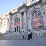 Personas conversan frente a una pancarta de la exposición 'Grabados mexicanos a la vanguardia', colgada en la fachada del Museo Metropolitano (Met), este lunes en Nueva York (Estados Unidos). EFE/Ángel Colmenares