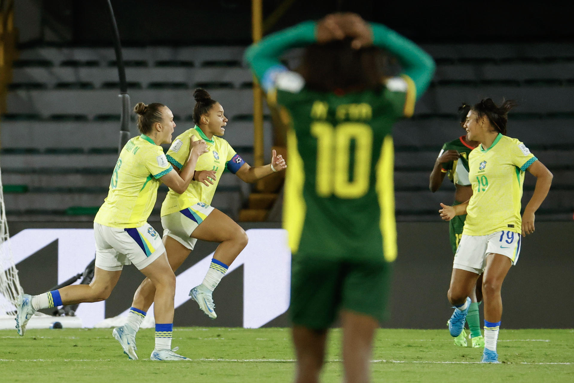 Dudinha (2-i), delantera de Brasil, fue registrada este miércoles, 11 de septiembre, al celebrar con un par de compañeras de selección un gol que le anotó a Camerún, durante un partido de los octavos de final del Mundial FIFA femenino sub-20, en el estadio El Campín de Bogotá (Colombia). EFE/Mauricio Dueñas
