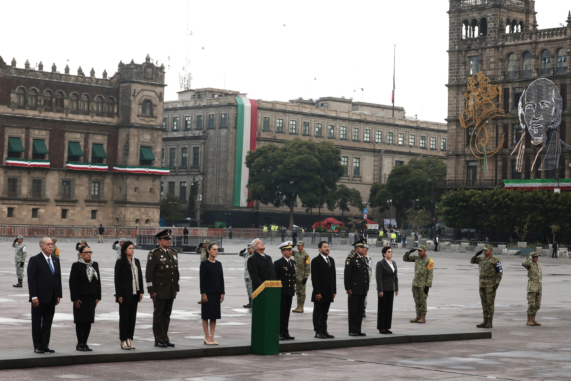 El presidente de México, Andrés Manuel López Obrador (c) y la mandataria electa Claudia Sheinbaum (5-i) participan en una ceremonia en honor a las víctimas de los sismos de 1985 y 2017 este jueves, realizada en la Plaza de la Constitución de la Ciudad de México (México). EFE/ José Méndez
