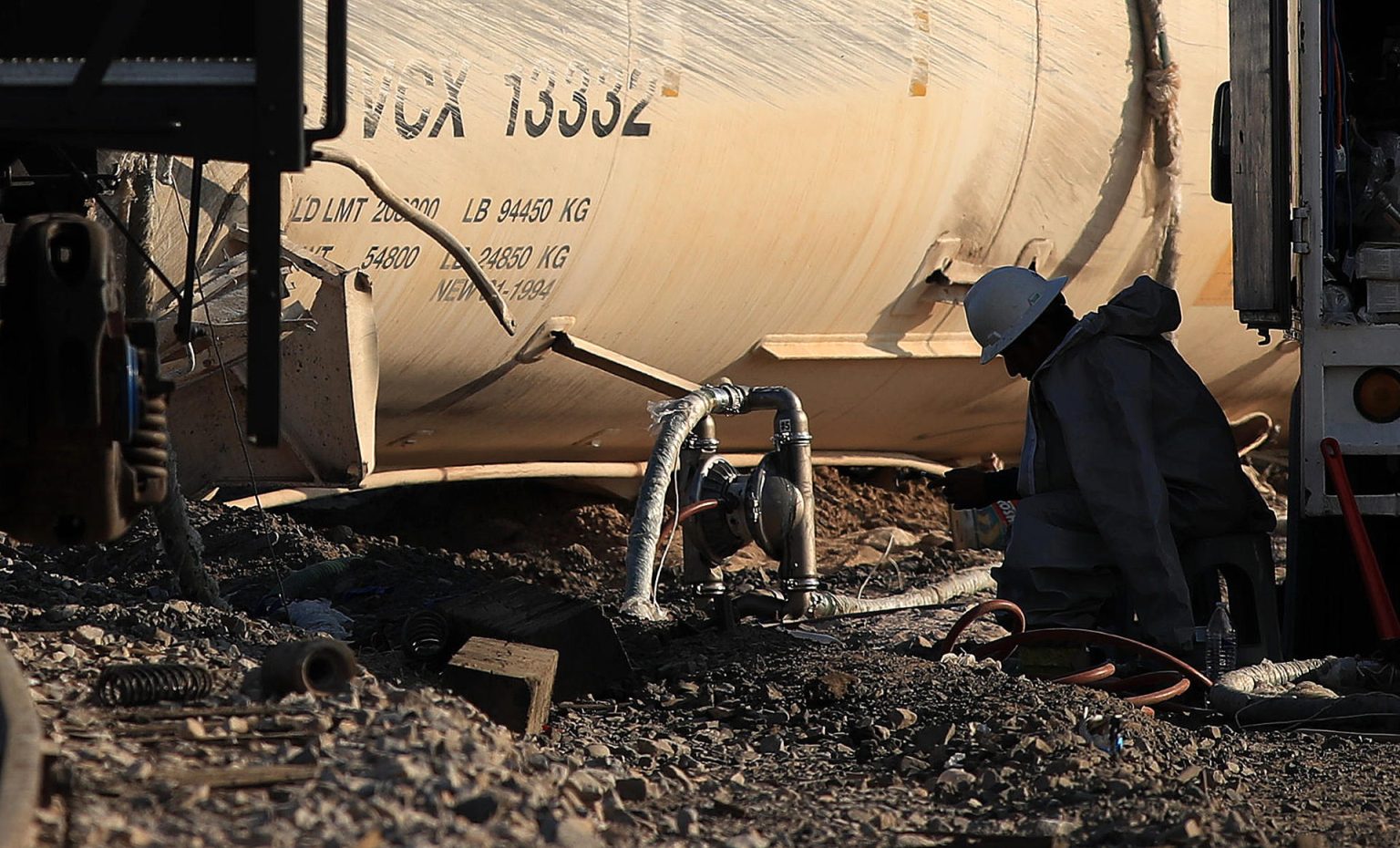 Personas trabajan este jueves en el sitio donde se descarriló un tren con ácido sulfúrico en Ciudad Juárez (México). EFE/Luis Torres