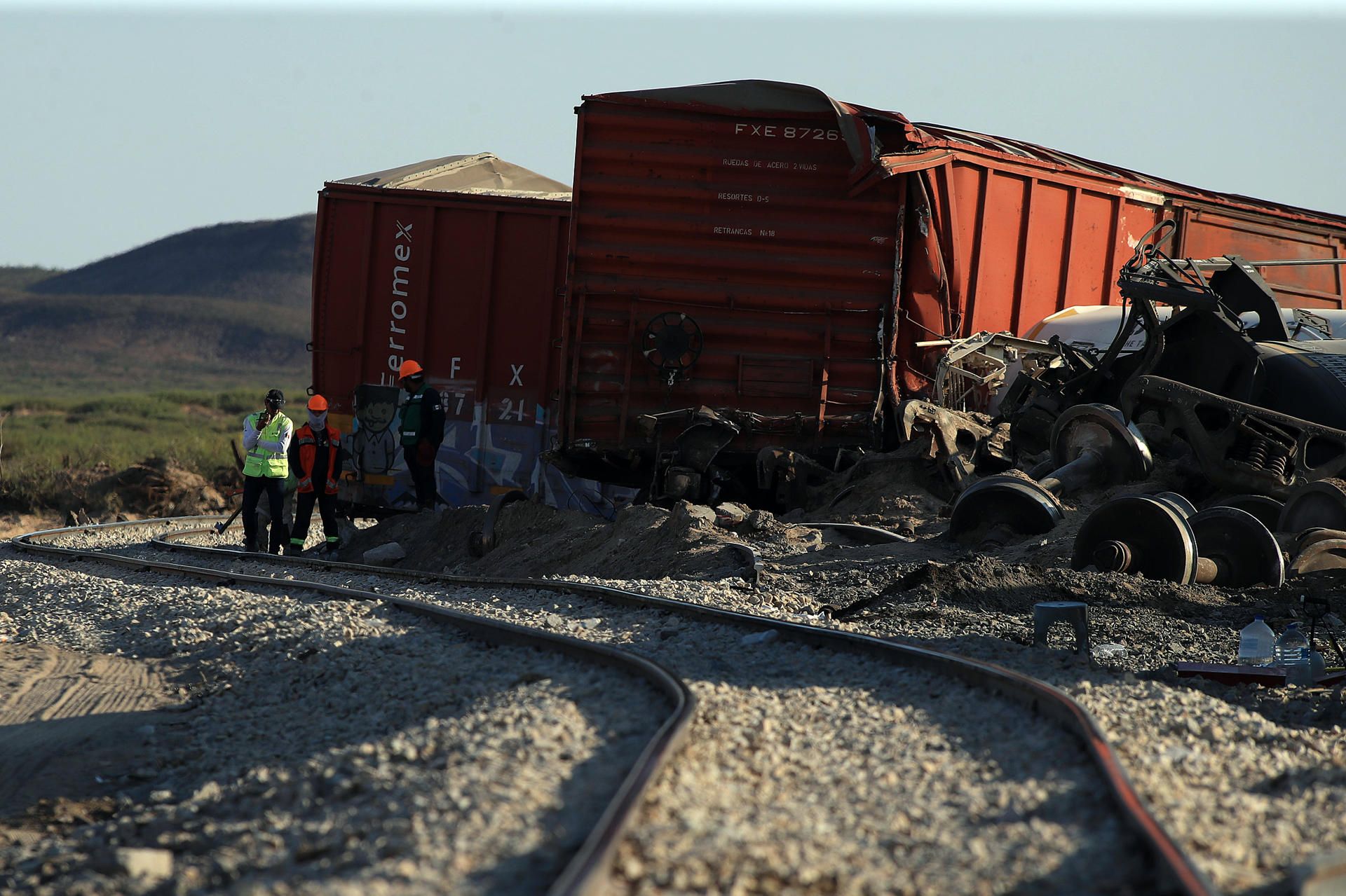 Personas trabajan este jueves en el sitio donde se descarriló un tren con ácido sulfúrico en Ciudad Juárez (México). EFE/Luis Torres
