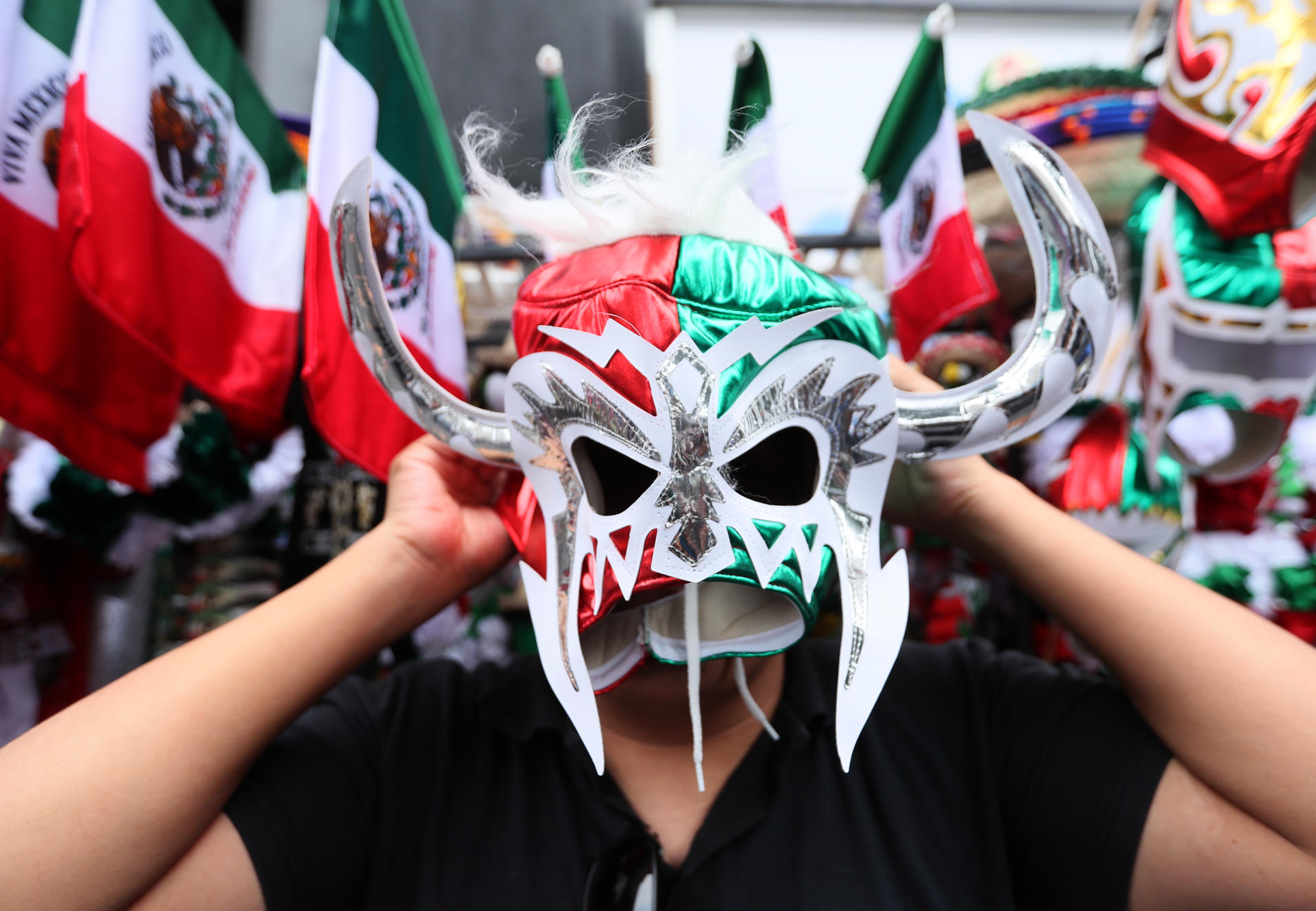 Un hombre se coloca una mascara con los colores patrios el 13 de septiembre de 2024, previo a la conmemoración del 224 aniversario de la independencia de México, en la Ciudad de México (México). EFE/Mario Guzmán
