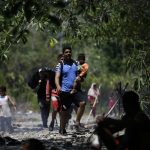 Grupos de personas migrantes caminan en la selva del Darién, para luego ser trasladados en canoa desde la Quebrada León hasta a la comunidad de Bajo Chiquito (Panamá). EFE/ Bienvenido Velasco