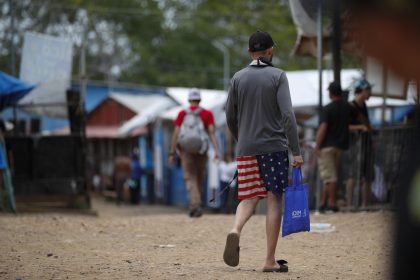 Un migrante camina vistiendo una prenda impresa con la bandera de los Estados Unidos en la Estación Temporal de Recepción Migratoria (ETRM), este jueves en Lajas Blancas, Darién (Panamá). EFE/Bienvenido Velasco