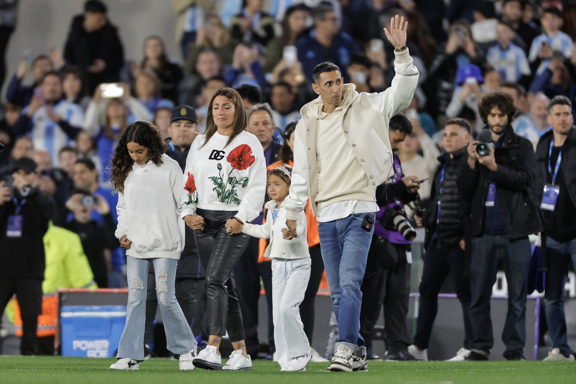 El jugador argentino Ángel di María (d) saluda a su ingreso al campo acompañado por su familia previo a un partido de las eliminatorias sudamericana para el Mundial 2026. EFE/ Juan Ignacio Roncoroni
