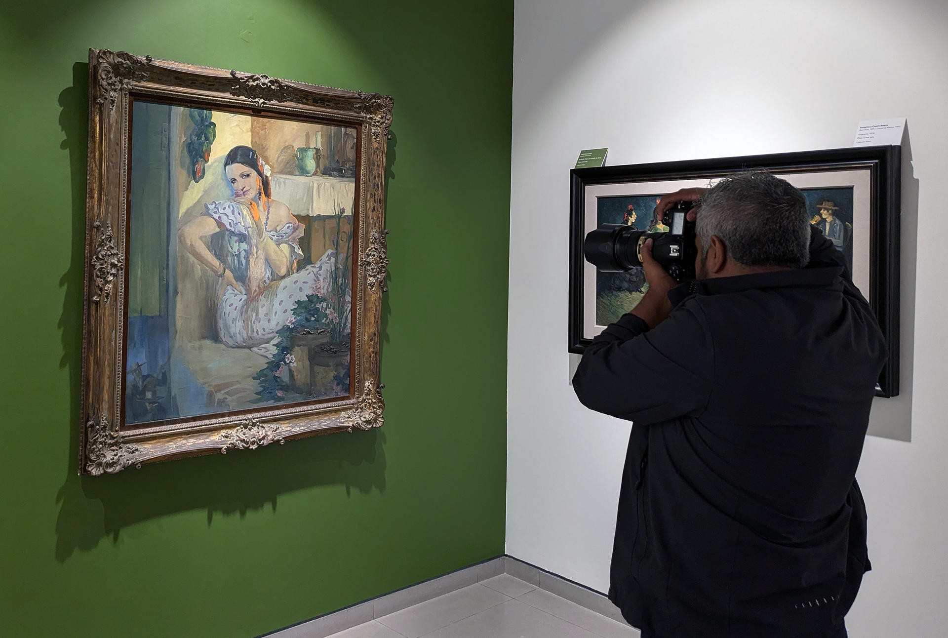 Fotografía del 13 de septiembre de 2024 de una persona tomando una fotografía en la exposición 'El Triunfo de la Espiga: 85 años de arte del exilio español', en la ciudad de Xalapa (México). EFE/ Miguel Victoria
