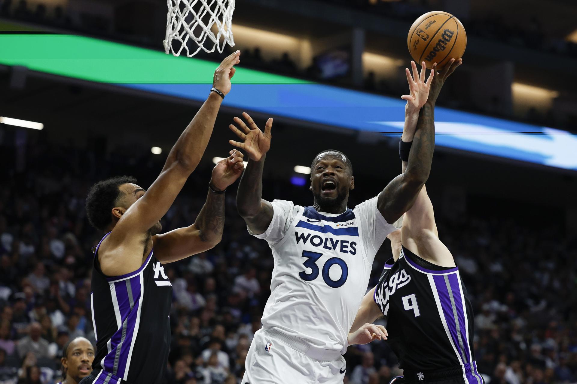 Los jugadores de los Sacramento Kings Trey Lyles (iz) y Kevin Huerter, y de los Minnesota Timberwolves, Jaden McDaniels, durante el partido de la liga regular de la NBA, este jueves. EFE/EPA/JOHN G. MABANGLO
