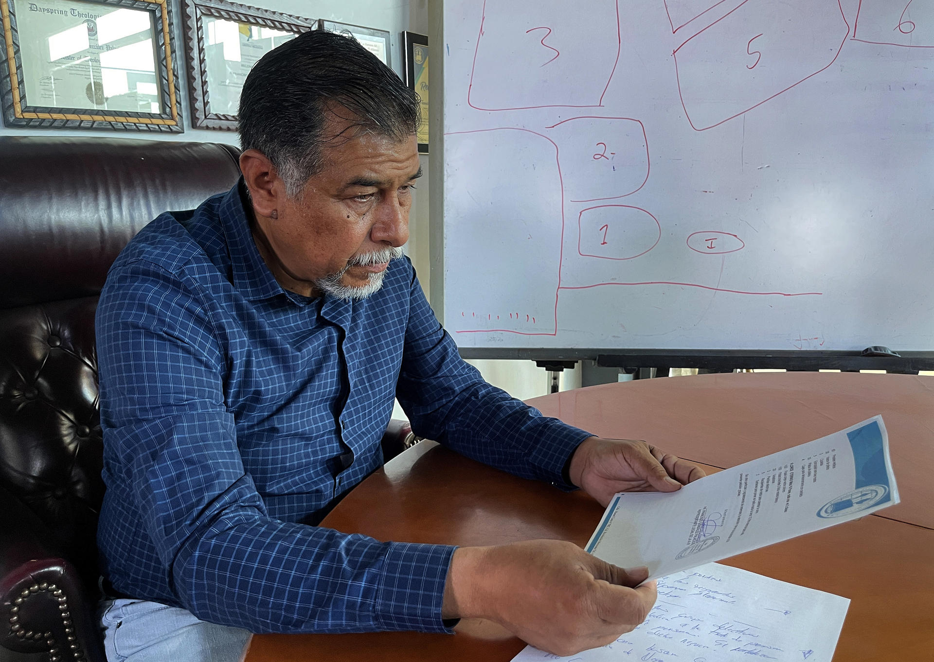 El pastor Francisco González, director del albergue 'Vida de la red de refugios migratorios Somos Uno por Juárez', lee documentos el 11 de octubre de 2024 durante una entrevista con EFE en Ciudad Juárez en el estado de Chihuahua (México). EFE/Luis Torres
