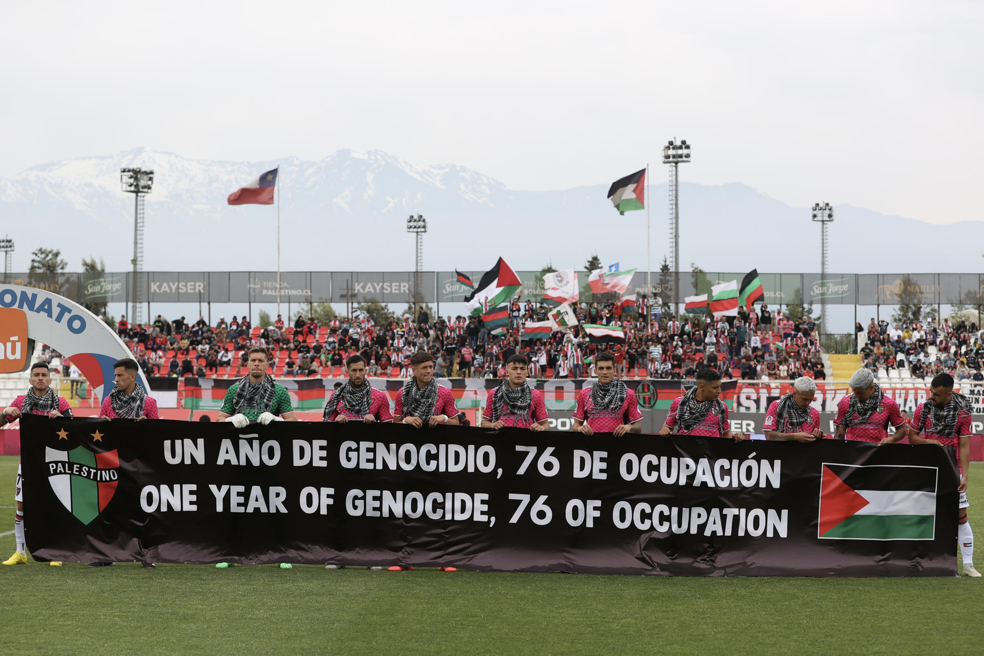 Fotografía cedida por Comunicaciones Club Deportivo Palestino de jugadores de ese equipo sosteniendo una pancarta antes de empezar un partido este domingo, en Santiago de Chile (Chile). . EFE/ Comunicaciones Club Deportivo Palestino /
