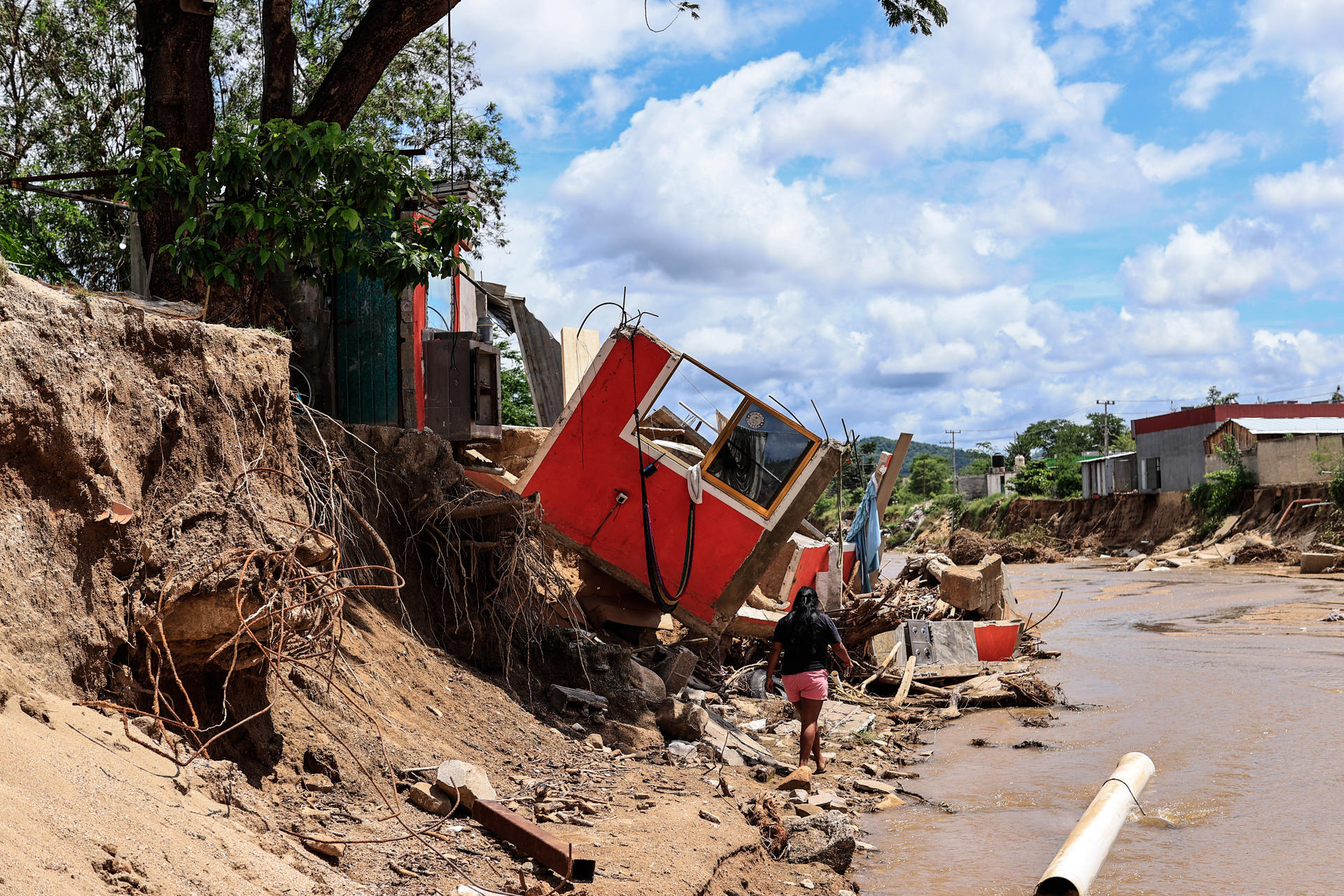 Verónica López Galindo posa frente a los escombros de su casa, destruida por la creciente del río de San Agustín tras el paso del huracán John, este viernes en Acapulco (México). EFE/David Guzmán
