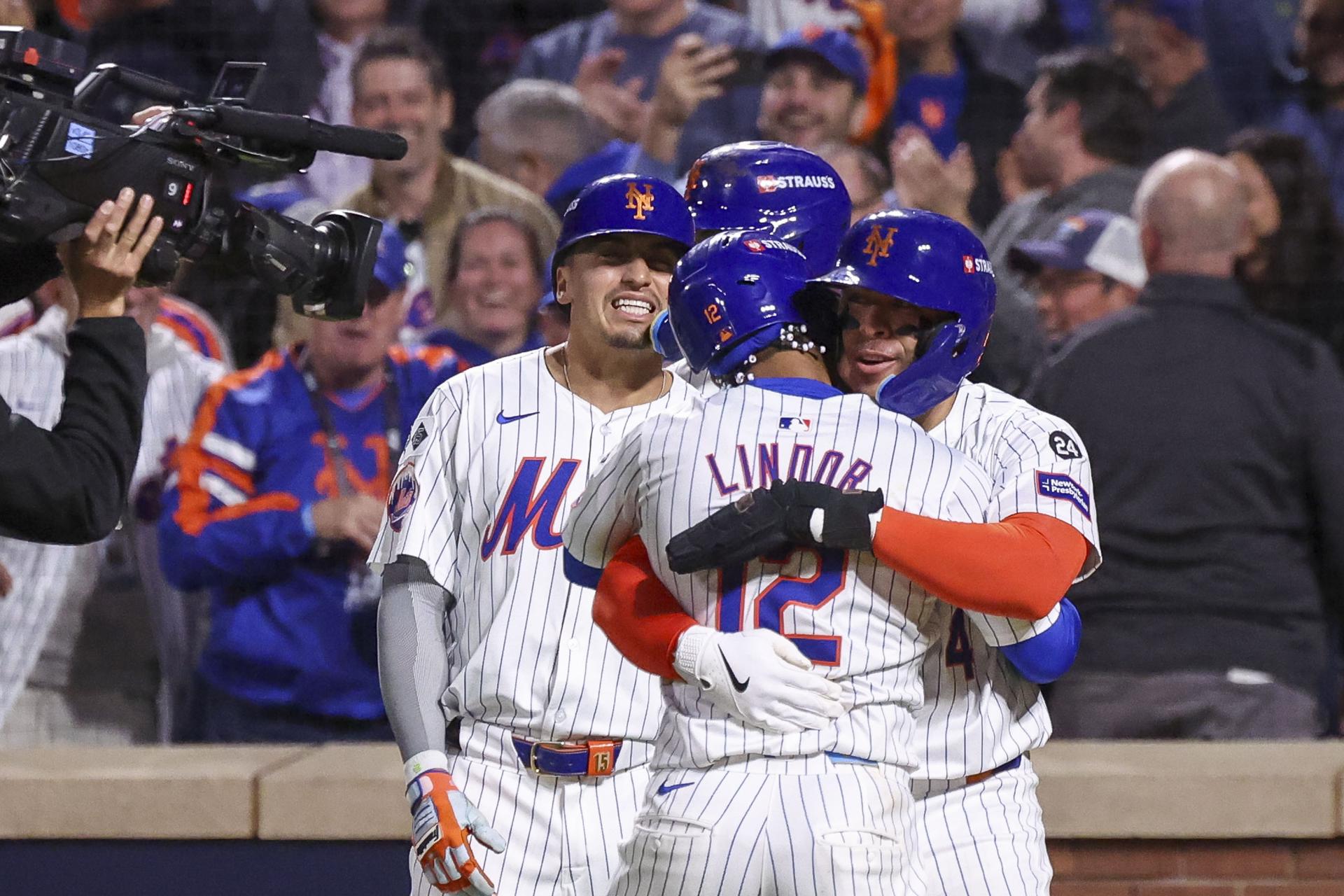 El bateador de los Mets de Nueva York, el puertorriqueño Francisco Lindor (c) se abraza con un compañero luego de conseguir un cuadrangular ante los Filis de Filadelfia. EFE/ SARAH YENESEL
