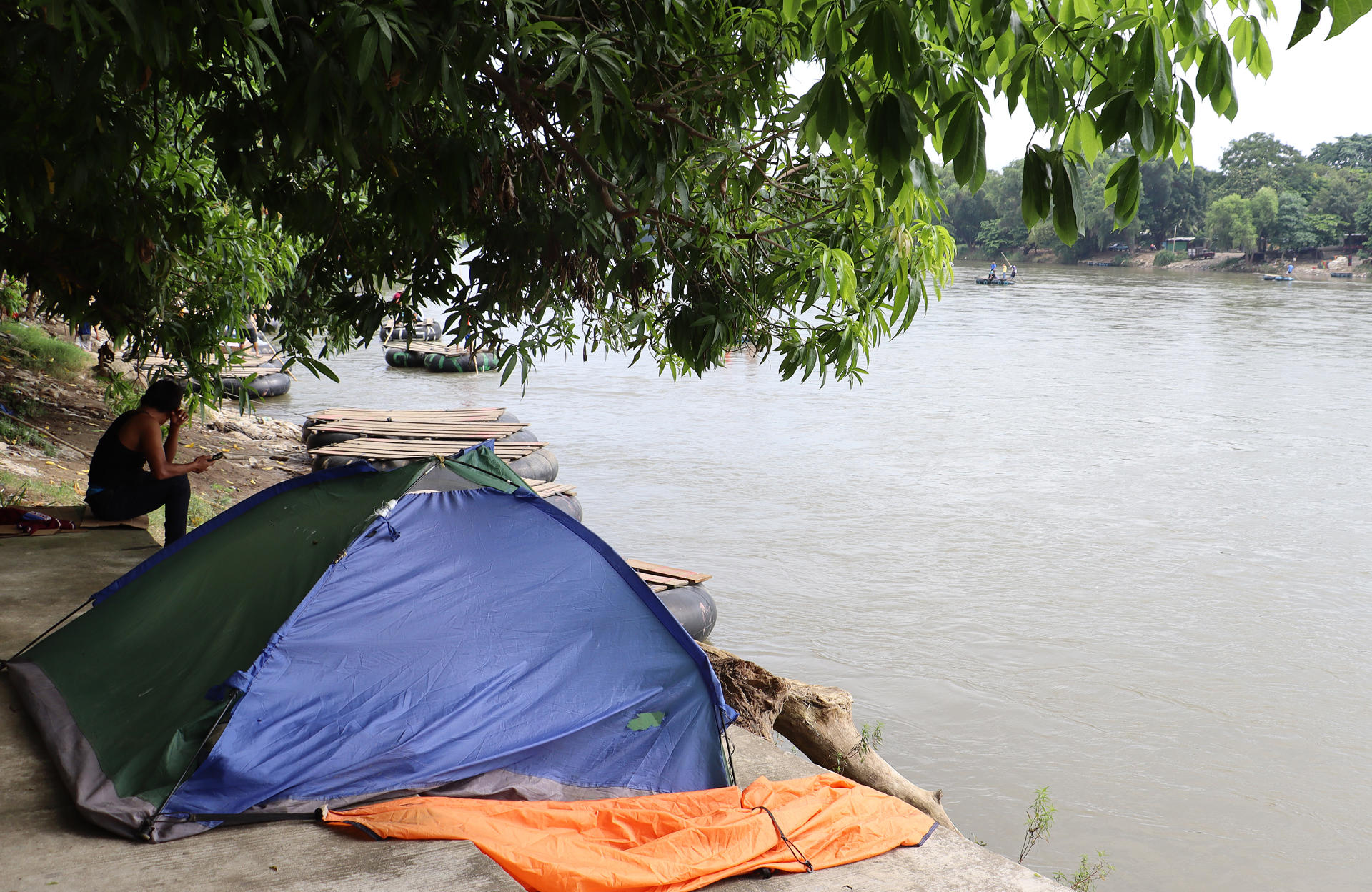 Un migrante descansa junto a una tienda campaña a la orilla del río Suchiateen este viernes, en Suchiate (México). EFE/ Juan Manuel Blanco
