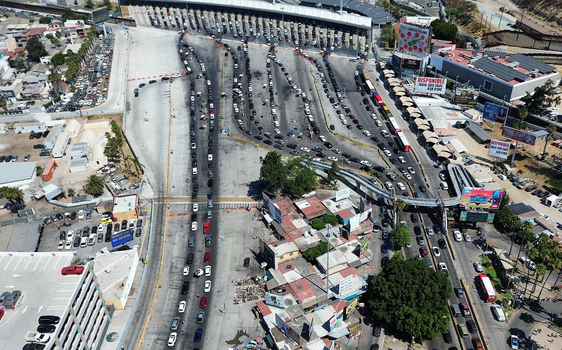 Fotografía aérea de vehículos haciendo fila para cruzar la frontera hacia Estados Unidos por la garita de San Isidro, este jueves, en la ciudad de Tijuana, estado de Baja California (México). EFE/ Joebeth Terríquez
