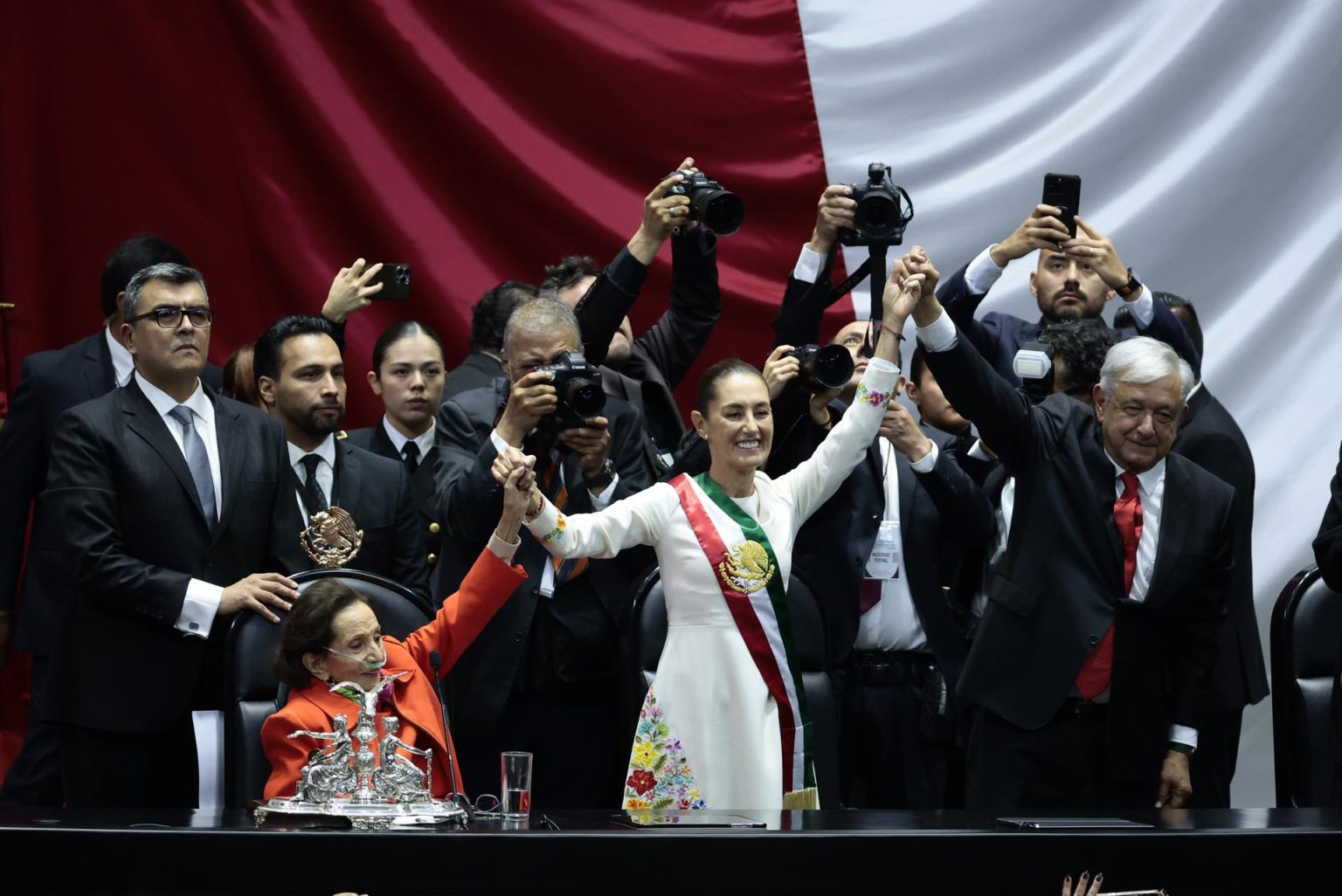 La presidenta de México Claudia Sheinbaum (c,i) acompañada del mandatario saliente, Andrés Manuel López Obrador (c,d), (2018-2024), saludan al termino de la toma de protesta en la Cámara de Diputados este martes en la Ciudad de México (México). EFE/José Méndez