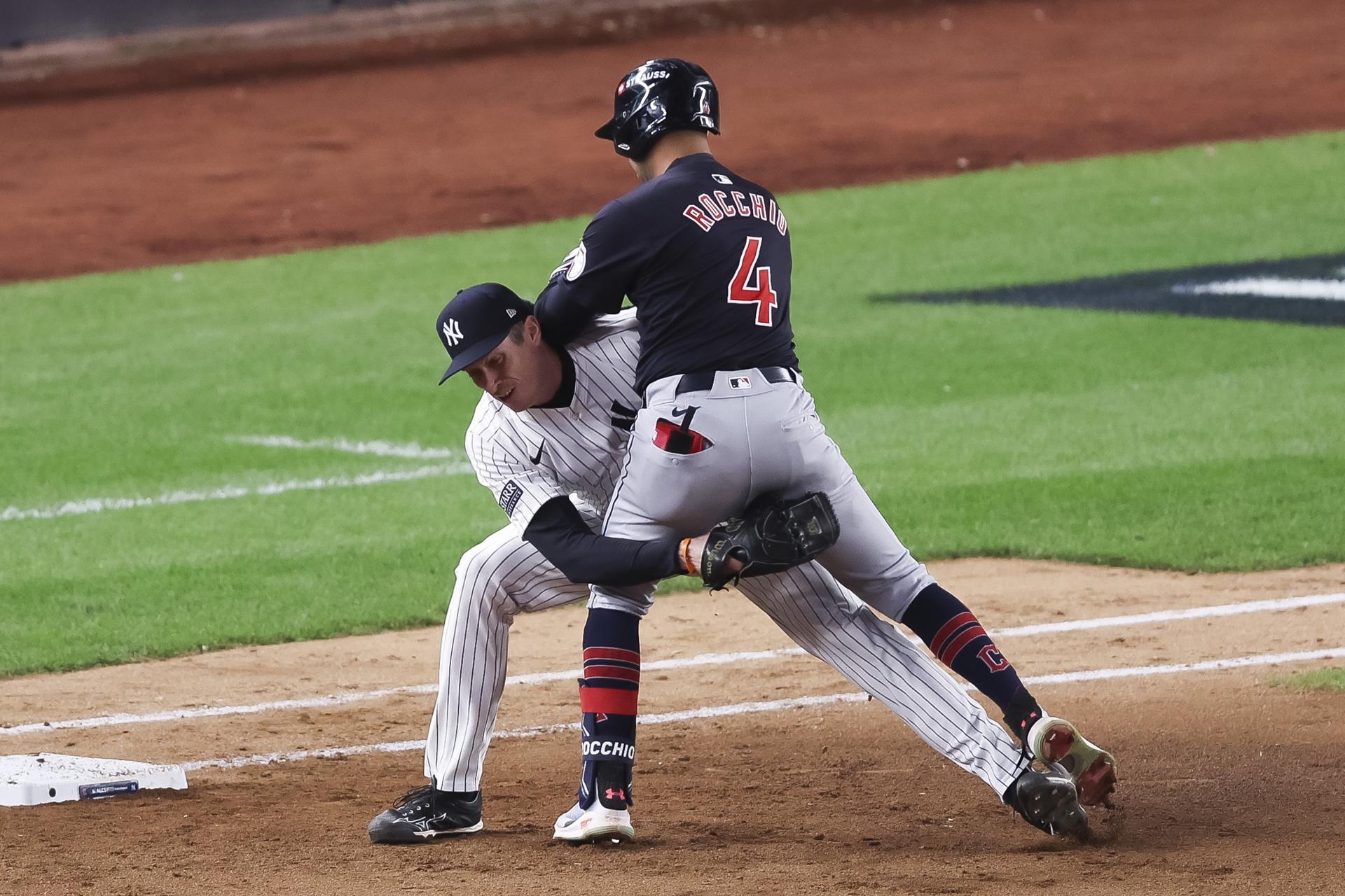 Brayan Rocchio (d) de los Guardianes choca con el lanzador de los Yankees Tim Hill (i) en la primera base durante la octava entrada del primer juego de la Serie de la Liga Americana de las Grandes Ligas, este lunes en Nueva York. EFE/EPA/SARAH YENESEL
