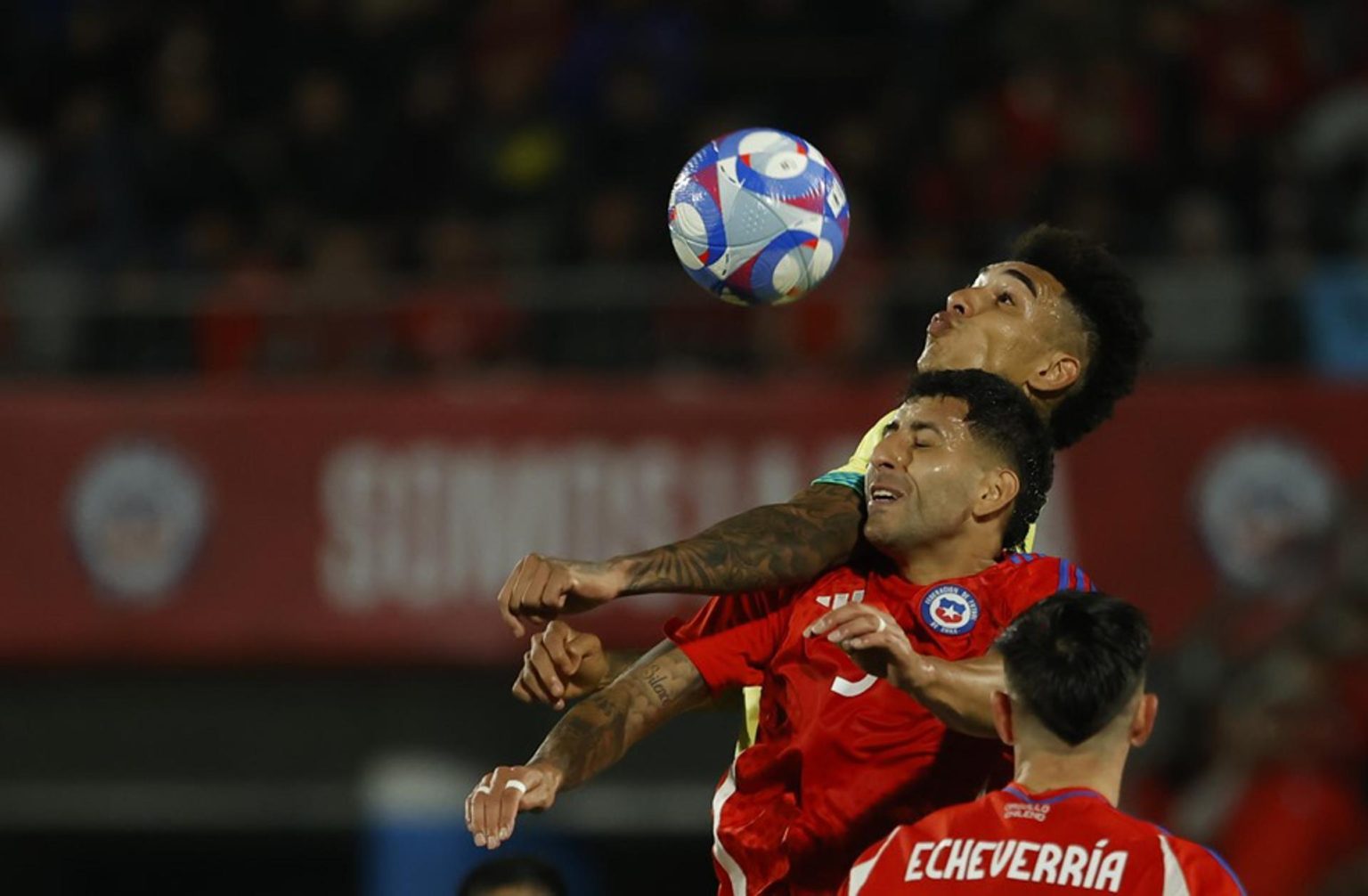 Guillermo Maripán (abajo) de Chile disputa un balón con Igor Jesus Maciel da Cruz (arriba) de Brasil en un partido de las eliminatorias sudamericanas para el Mundial de 2026. EFE/ Elvis González