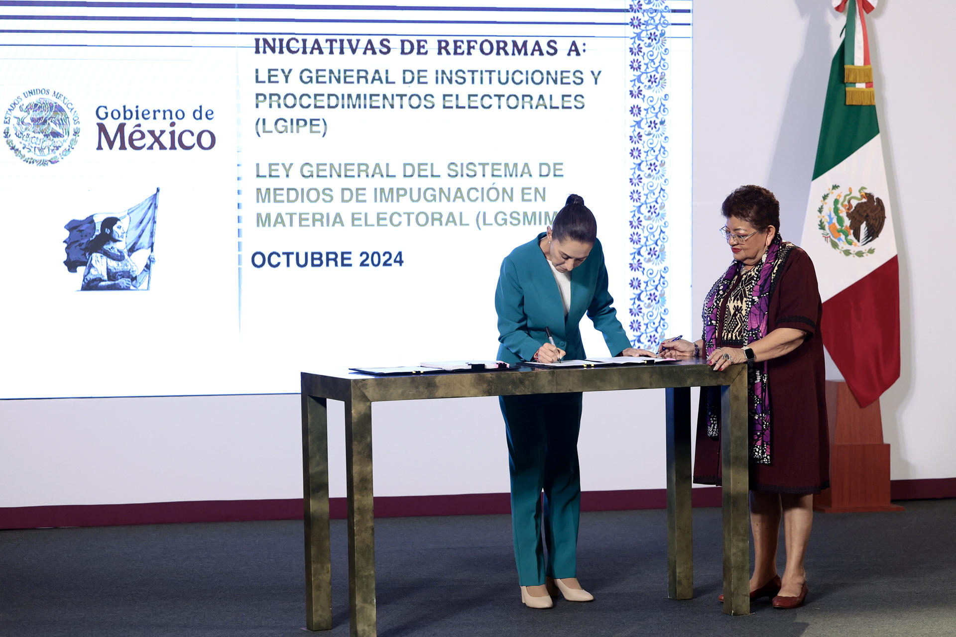 La presidenta de México, Claudia Sheinbaum (i), y la consejera jurídica de la Presidencia, Ernestina Godoy, firman dos iniciativas este lunes, durante una conferencia de prensa en Palacio Nacional de la Ciudad de México (México). EFE/ José Méndez
