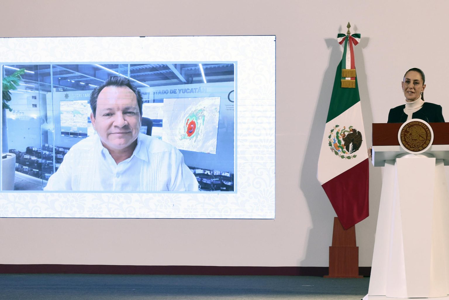 La presidenta de México Claudia Sheinbaum (d) y el gobernador de Yucatán, Joaquín Díaz Mena (pantalla) participan este martes durante una conferencia de prensa matutina en Palacio Nacional de la Ciudad de México (México). EFE/José Méndez