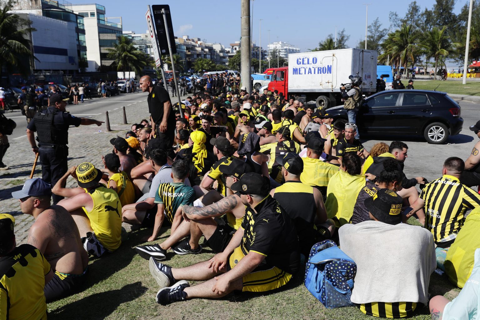 Fotografía tomada el 23 de octubre de 2024 a fanáticos del club Peñarol detenidos por la policía de Río de Janeiro por su presunta participación en disturbios antes del partido de ida de las semifinales de la Copa Libertadores que ganó Botafogo por 5-0. A dos días del encuentro de vuelta en Montevideo, las autoridades de Uruguay anunciaron que no permitirán hinchas brasileños en el estadio Campeón del Siglo. EFE/ André Coelho