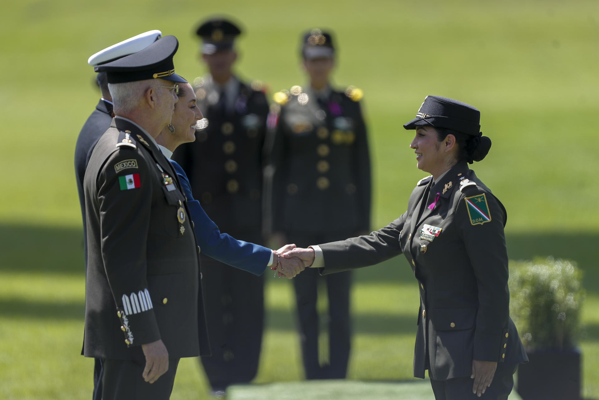 La presidenta de México, Claudia Sheinbaum (ci), saluda a una integrante de la fuerza pública durante la ceremonia de saludo a las Fuerzas Armadas y Guardia Nacional, este jueves en el Campo Marte de la Ciudad de México (México). EFE/ Isaac Esquivel
