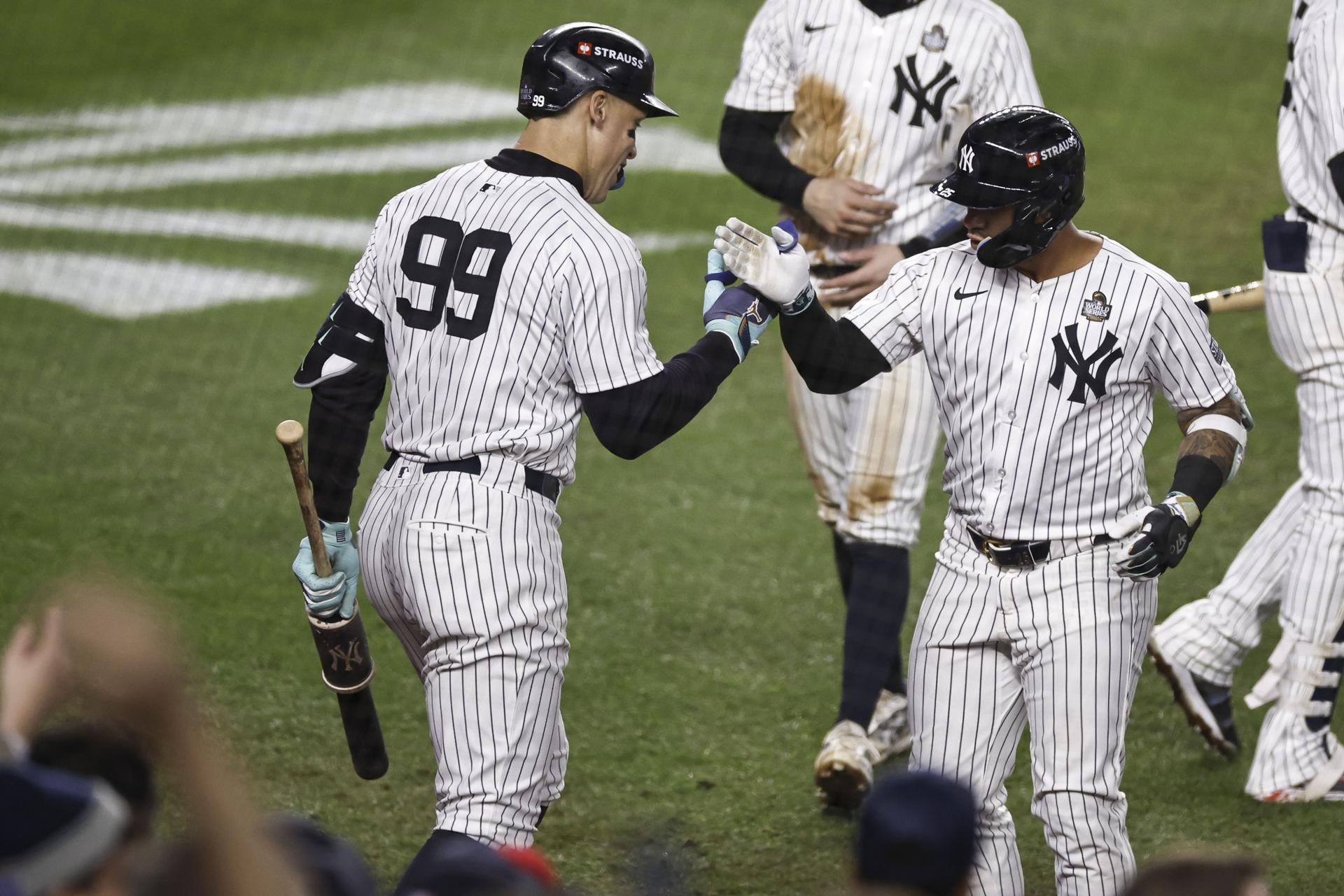 Gleyber Torres (D) de los Yankees de Nueva York es recibido por el jardinero central Aaron Judge (I) después de conectar un jonrón de tres carreras durante la octava entrada del cuarto juego de la Serie Mundial de las Grandes Ligas de Béisbol (MLB). EFE/EPA/CJ GUNTHER
