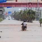 Imagen de archivo de dos personas en una moto que transitan por una calle inundada en Acapulco (México). EFE/ David Guzmán