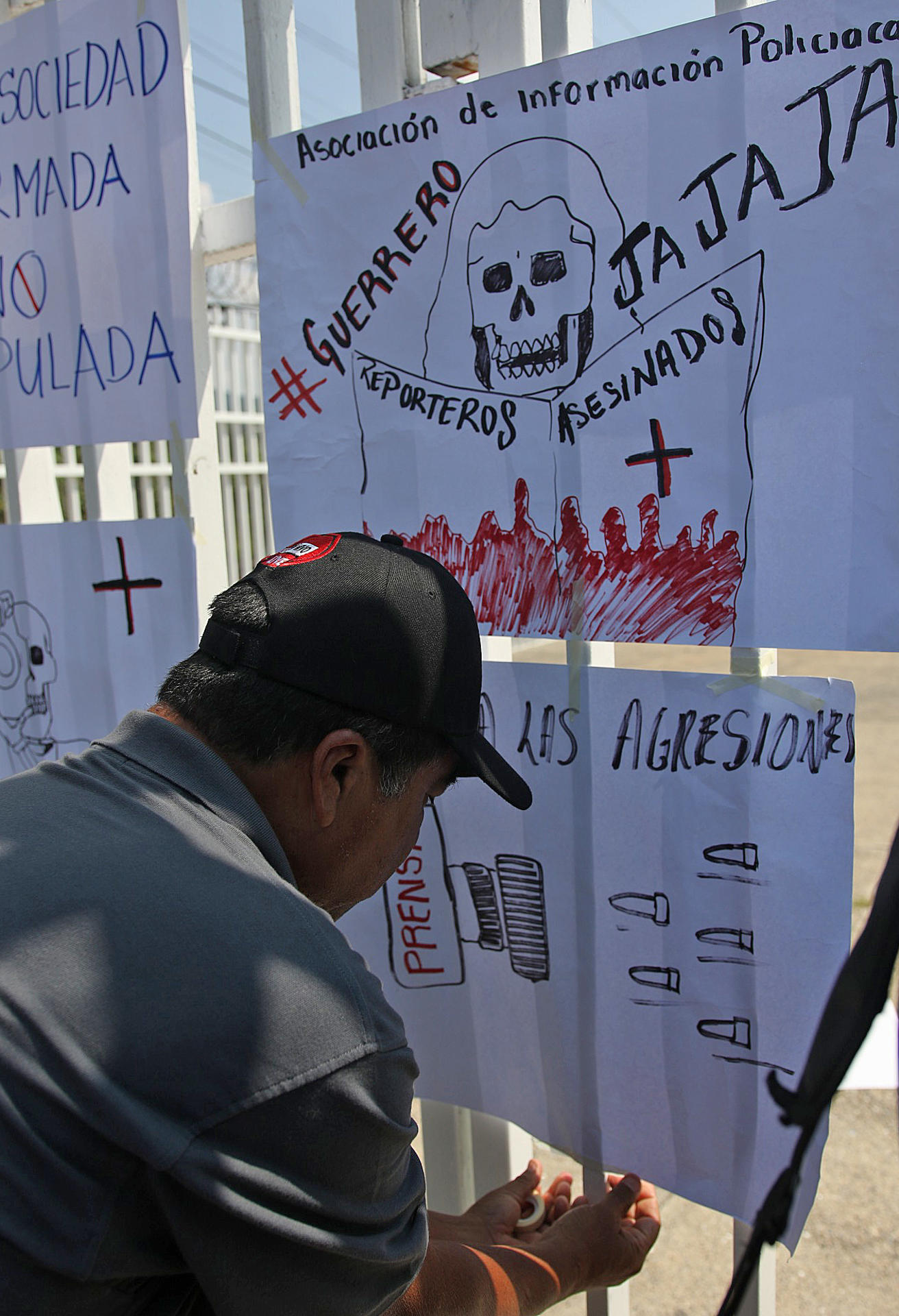 Una persona instala carteles durante una protesta frente a la delegación de la Fiscalía General de la República (FGR) este jueves, en el municipio de Chilpancingo (México). EFE/José Luis de la Cruz
