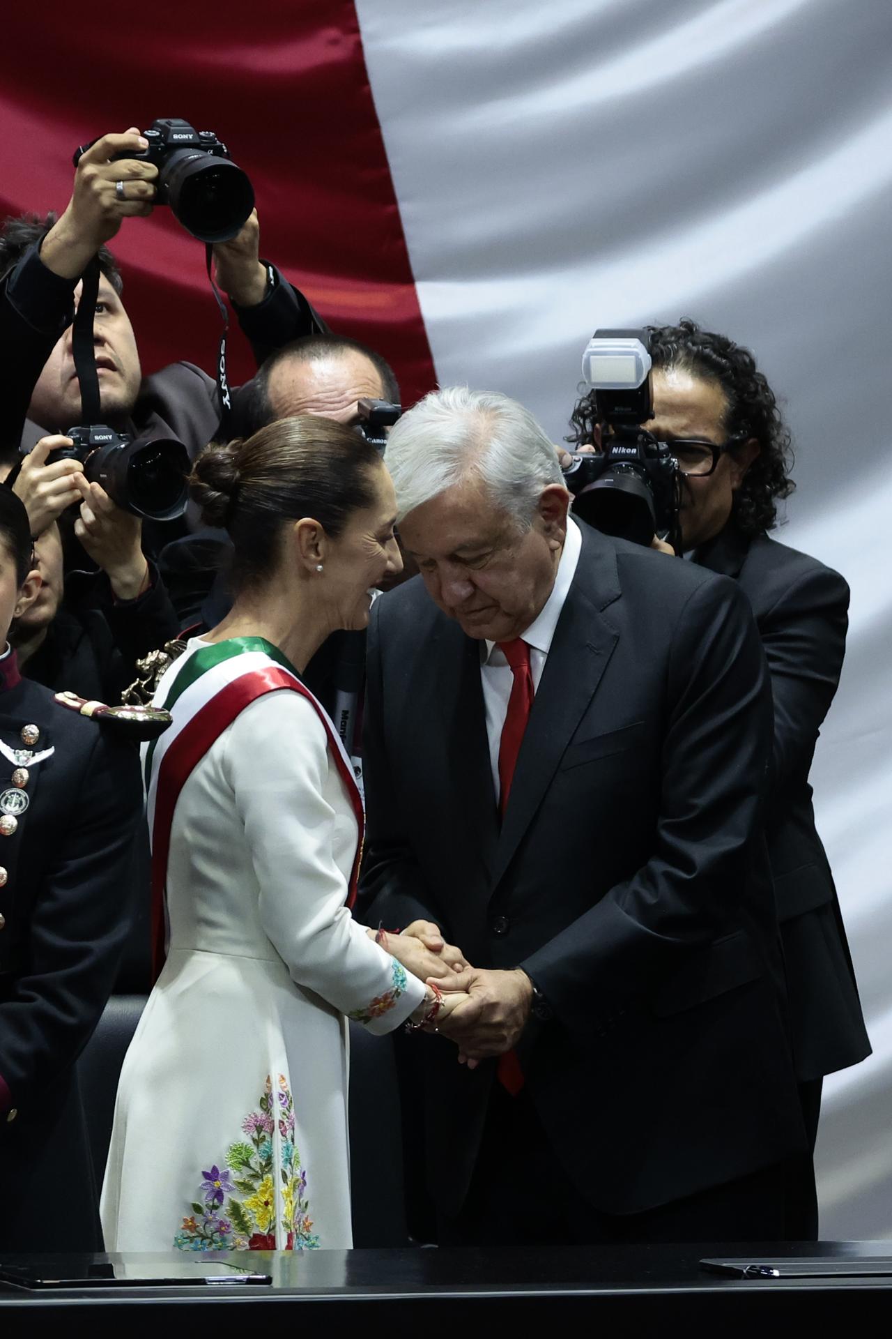 La presidenta de México Claudia Sheinbaum (i) acompañada del mandatario saliente, Andrés Manuel López Obrador (d), (2018-2024), conversan al termino de la toma de protesta en la Cámara de Diputados este martes en la Ciudad de México (México). EFE/José Méndez