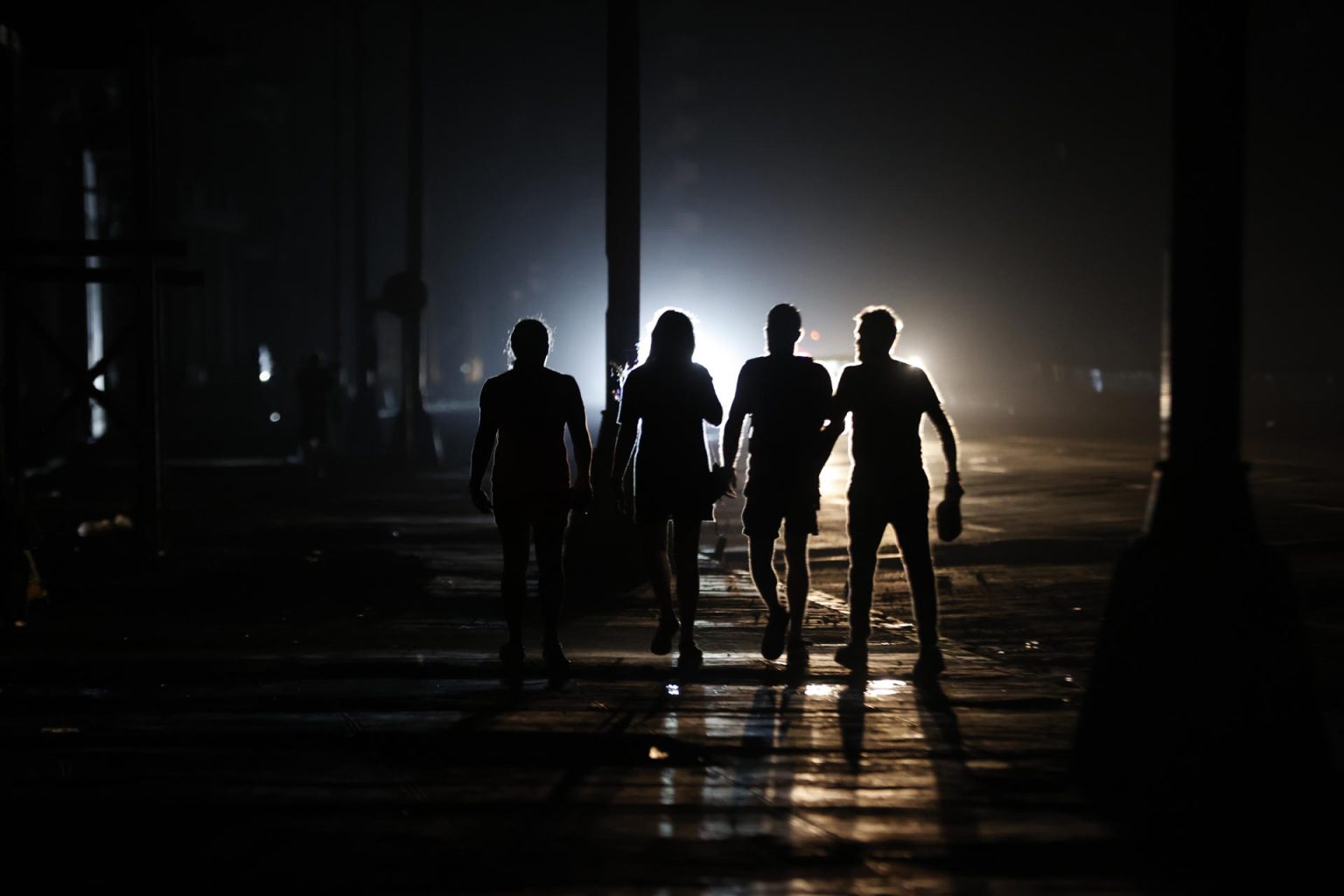 Personas caminan por una calle durante un apagón el domingo, en La Habana (Cuba). EFE/ Ernesto Mastrascusa