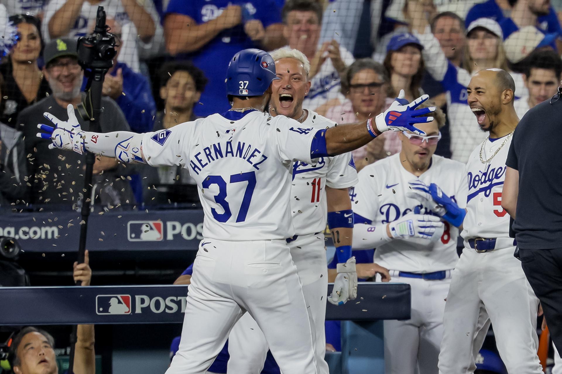 Teoscar Hernandez (i) celebra con Miguel Rojas (c) y Mookie Betts (d) de los Dodgers de Los Angeles luego de conseguir un jonron ante los Padres de San Diego. EFE/ALLISON DINNER
