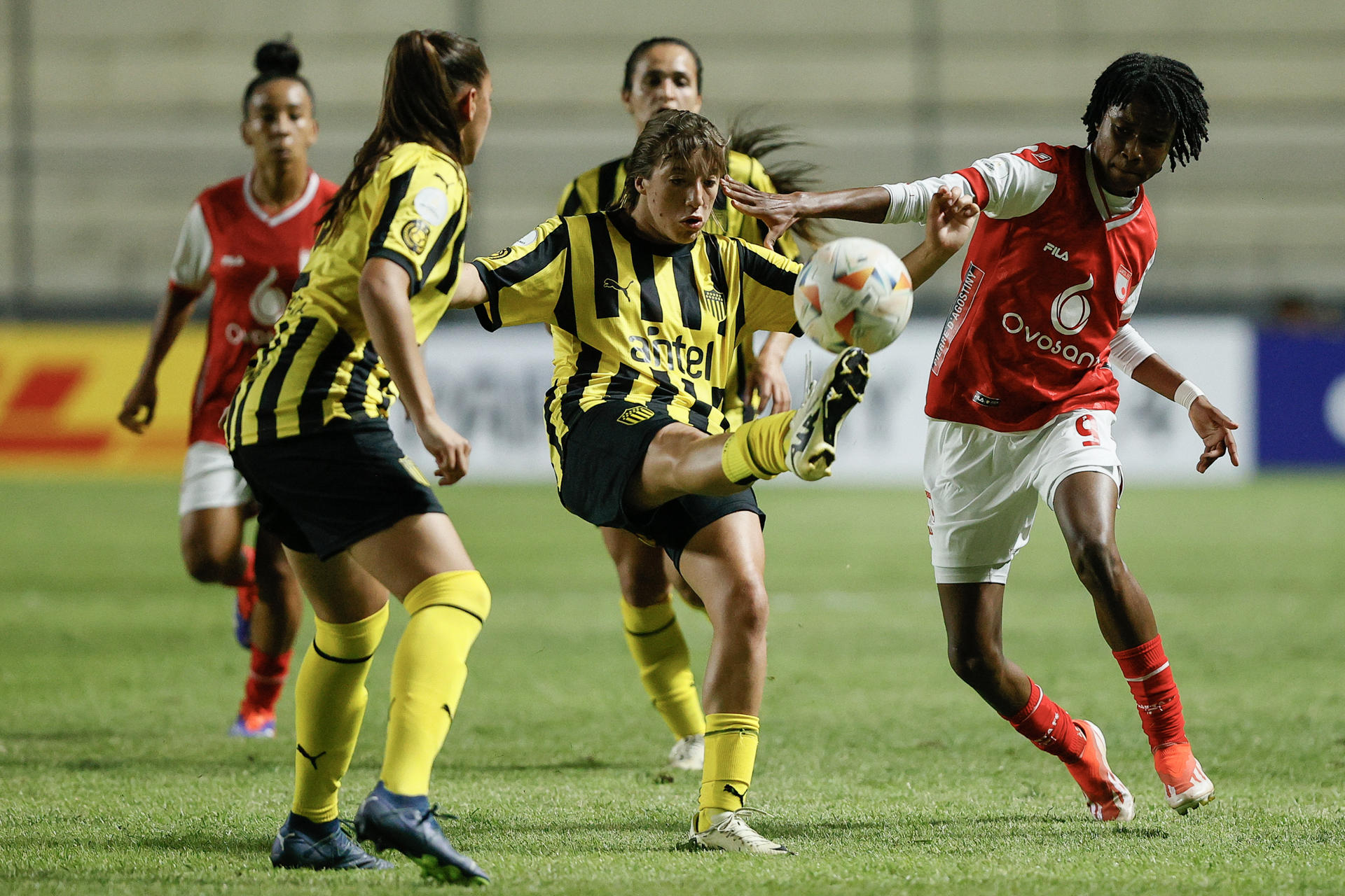 Pasaje del partido de la Copa Libertadores femenina jugado este viernes entre Peñarol, el equipo atigrado uruguayo, y el rojiblanco colombiano Independiente Santa Fe en el estadio asunceno Arsenio Erico.  EFE/ Juan Pablo Pino
