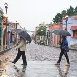 Imagen de archivo de dos personas que se protegen de la lluvia en el estado de Oaxaca (México). EFE/Daniel Ricardez