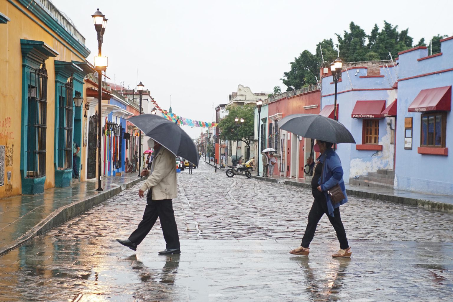 Imagen de archivo de dos personas que se protegen de la lluvia en el estado de Oaxaca (México). EFE/Daniel Ricardez