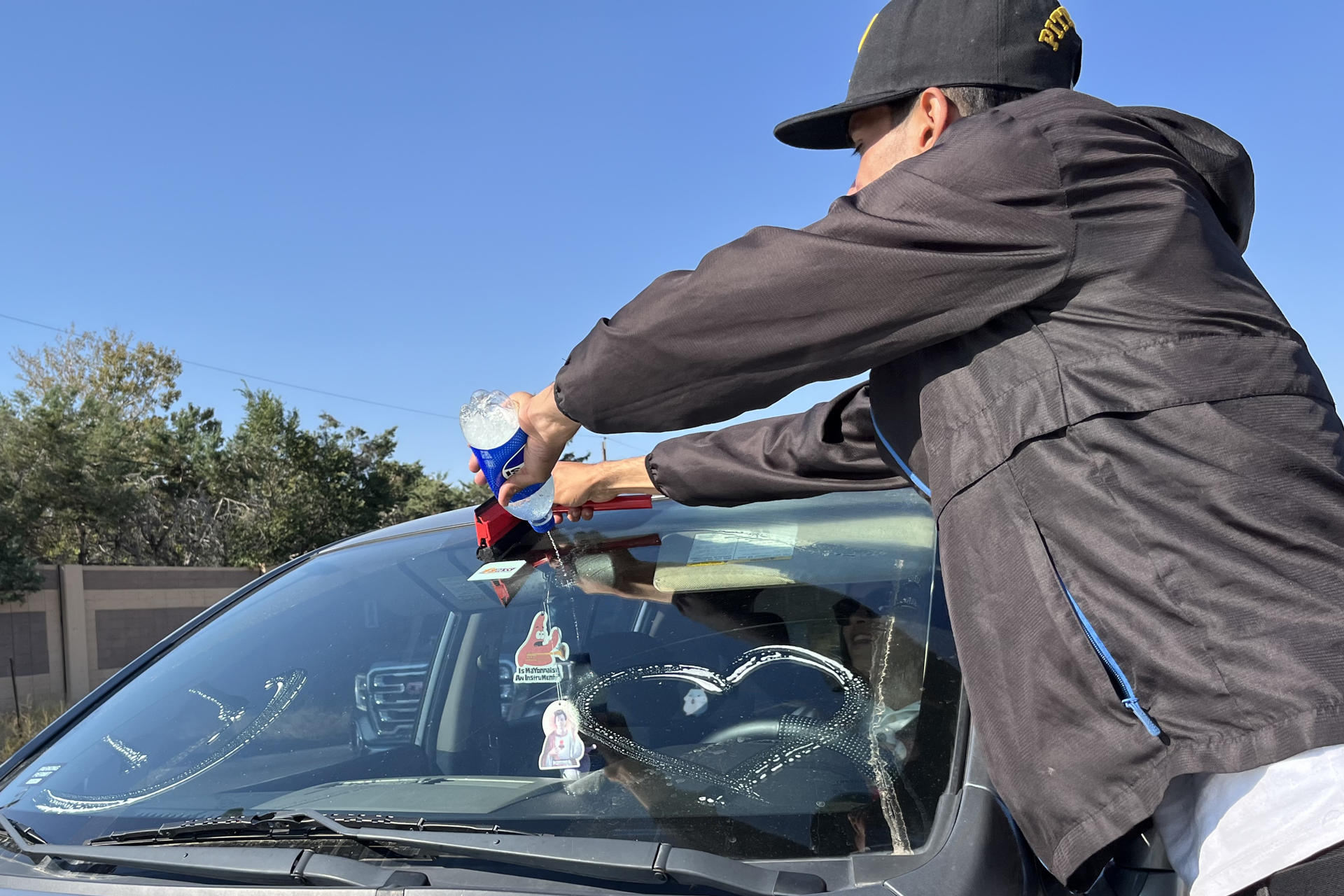 Migrantes venezolanos limpian el parabrisas de un carro, el 10 de octubre de 2024, en un avenida en Aurora (Estados Unidos). EFE/ Alejandra Arredondo
