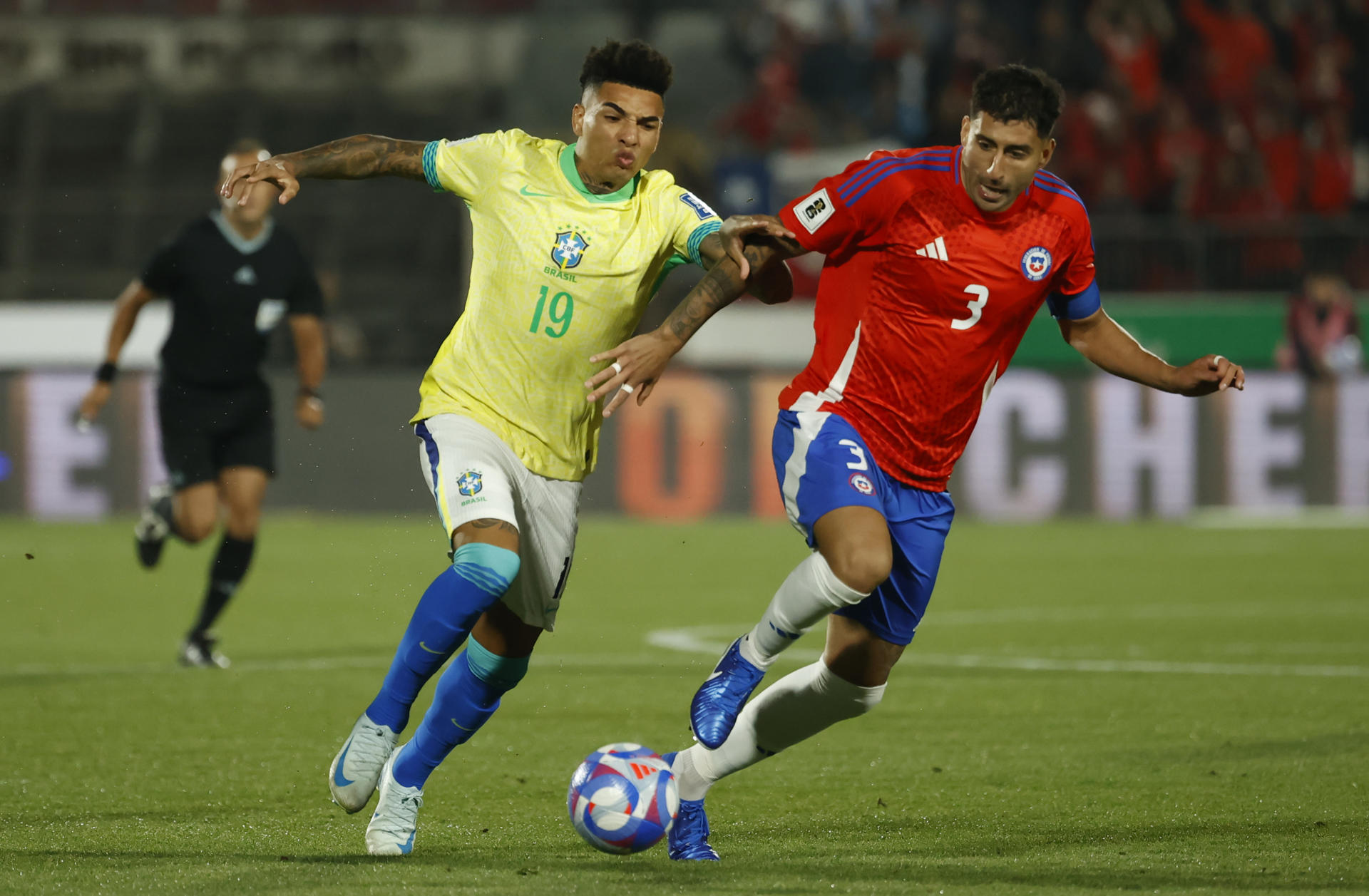 Guillermo Maripán (d) de Chile disputa un balón con Igor Jesus Maciel da Cruz de Brasil en un partido de las eliminatorias sudamericanas para el Mundial de 2026. EFE/ Elvis González
