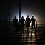 Personas caminan por una calle durante un apagón el domingo, en La Habana (Cuba). EFE/ Ernesto Mastrascusa